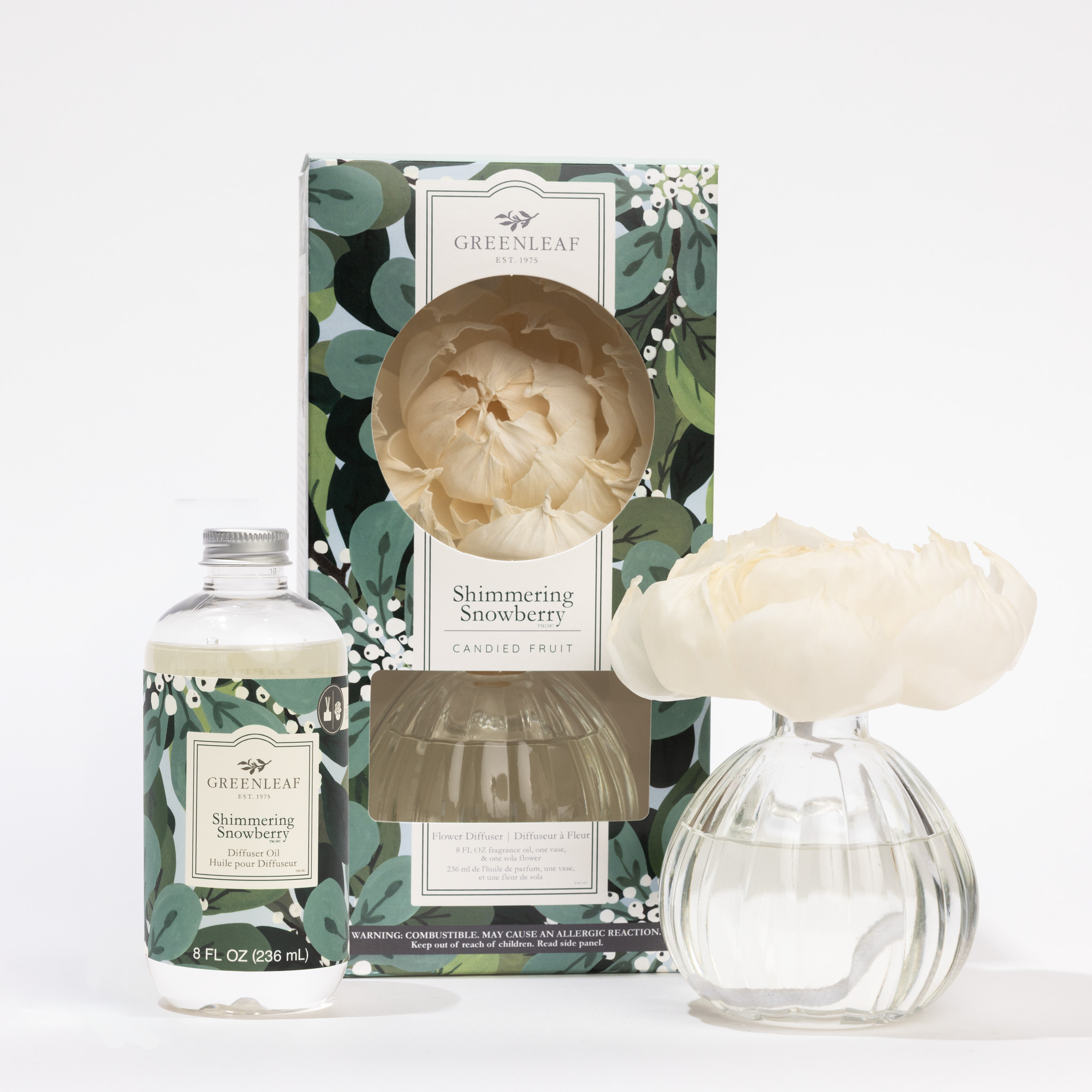 The Fast Bundle Shimmering Snowberry Flower Diffuser & Fragrance Refill Oil includes a floral box, clear fragrance oil bottle, and glass vase with a white flower diffuser—ideal for refreshing your space or as a refill.