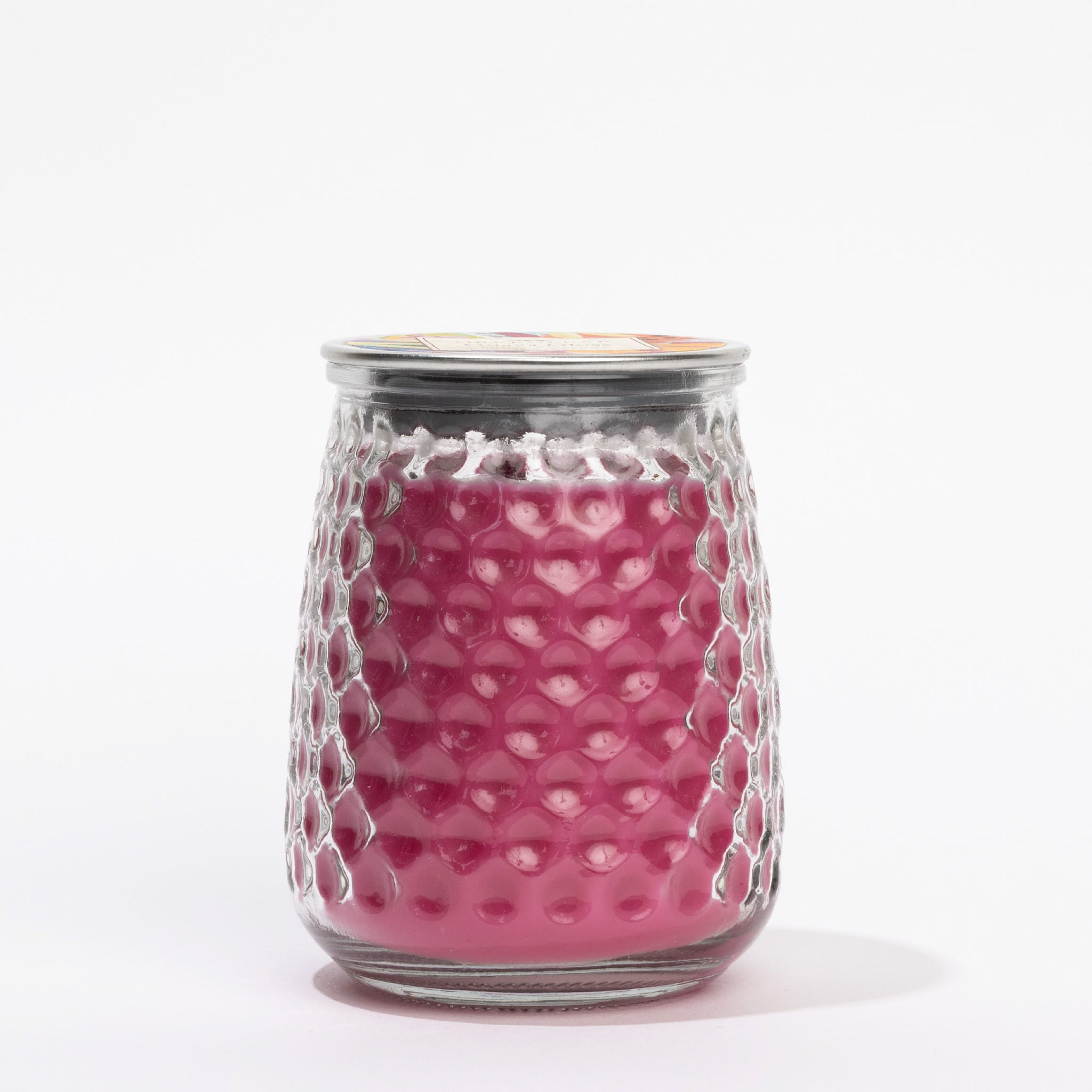 A vibrant pink Guava Gloss Signature Candle by Greenleaf Gifts sits in a textured honeycomb glass jar with a metal lid, displayed against a white background.