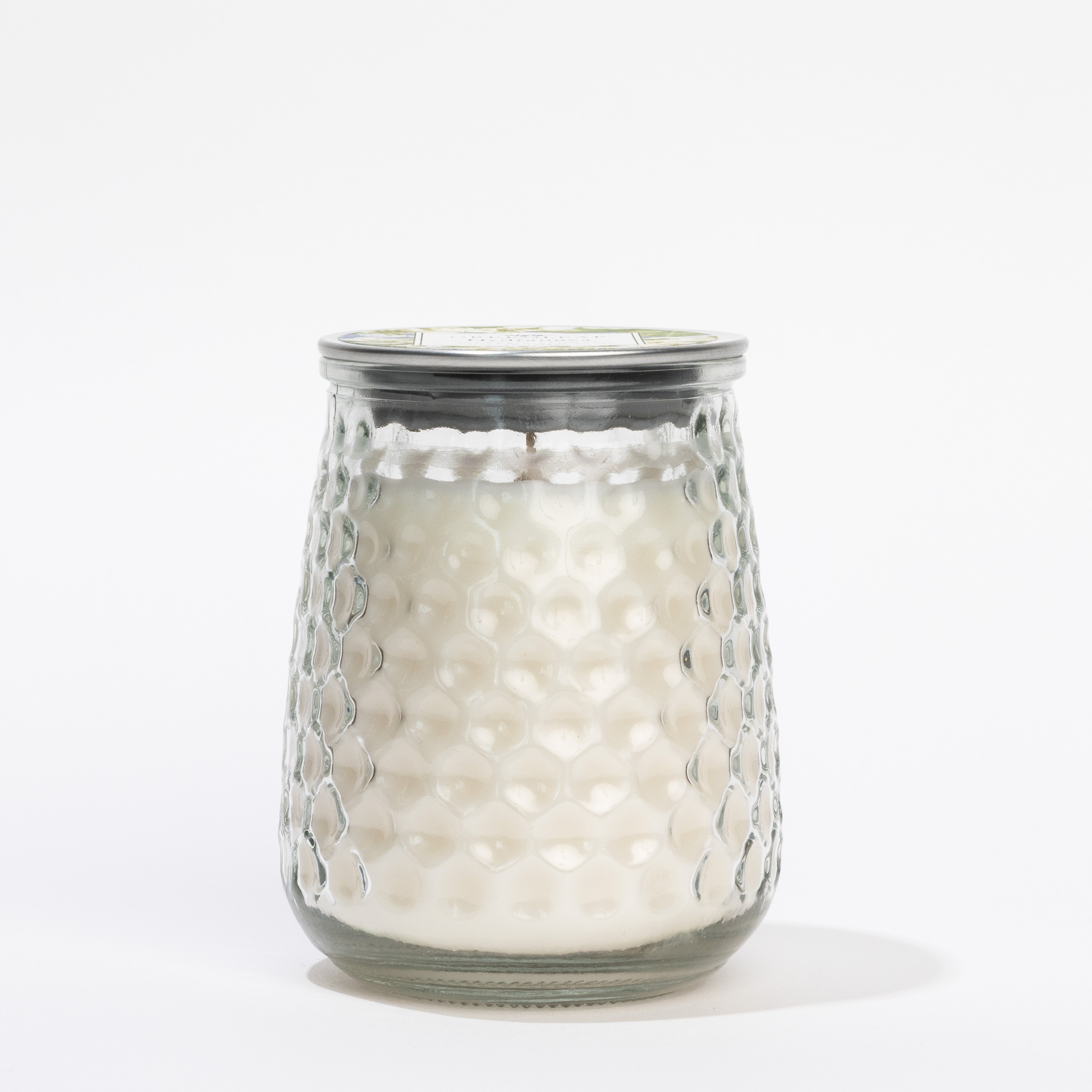 The Greenleaf Gifts Hydrangea Signature Candle features a white wax with hydrangea scent in a textured, honeycomb-patterned clear glass jar with a metal lid, displayed against a plain white background.