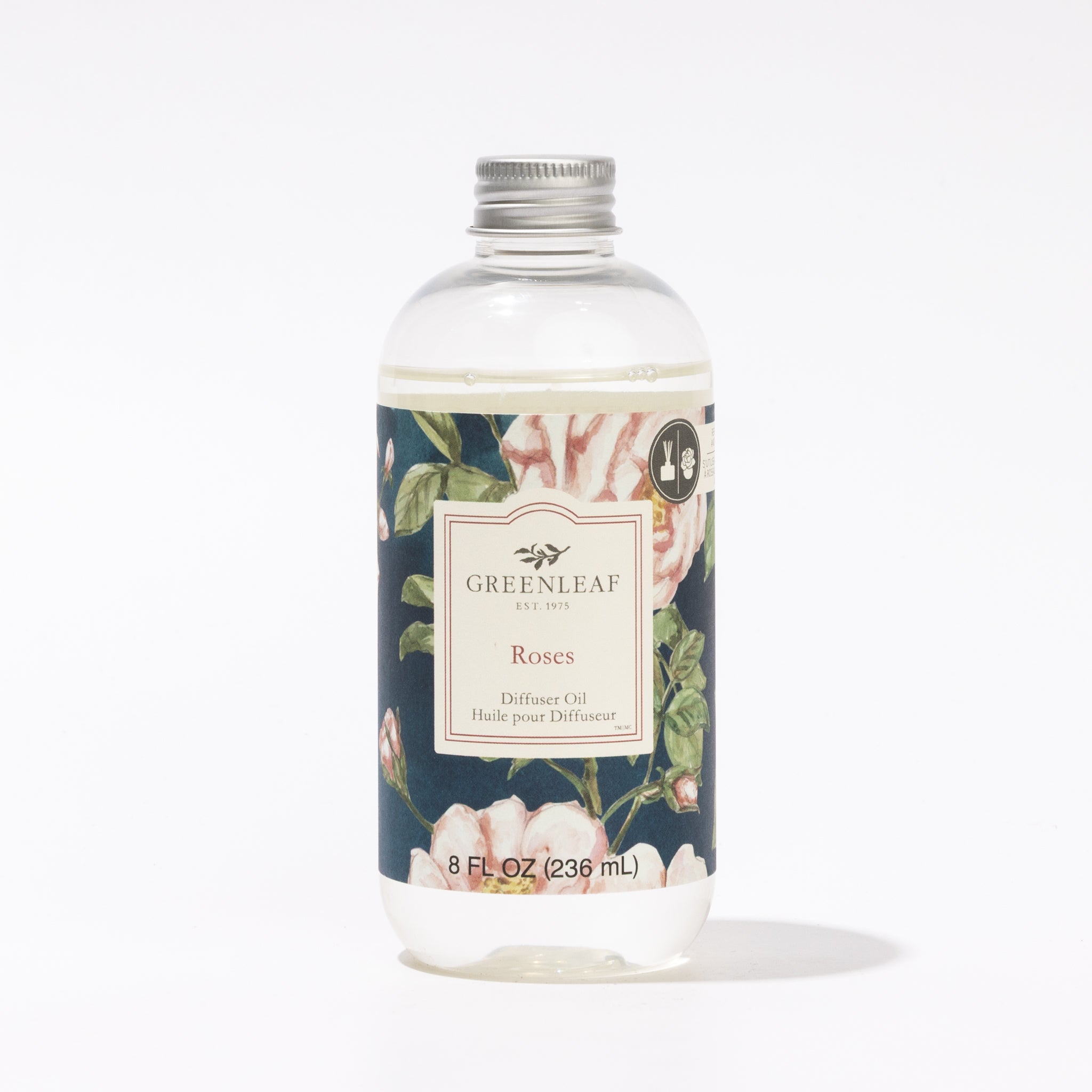 An 8 fl oz (236 ml) clear Greenleaf Gifts Roses Diffuser Oil bottle features a silver screw cap and a floral label with pink roses and green leaves on a dark background—ideal as a flower diffuser refill.