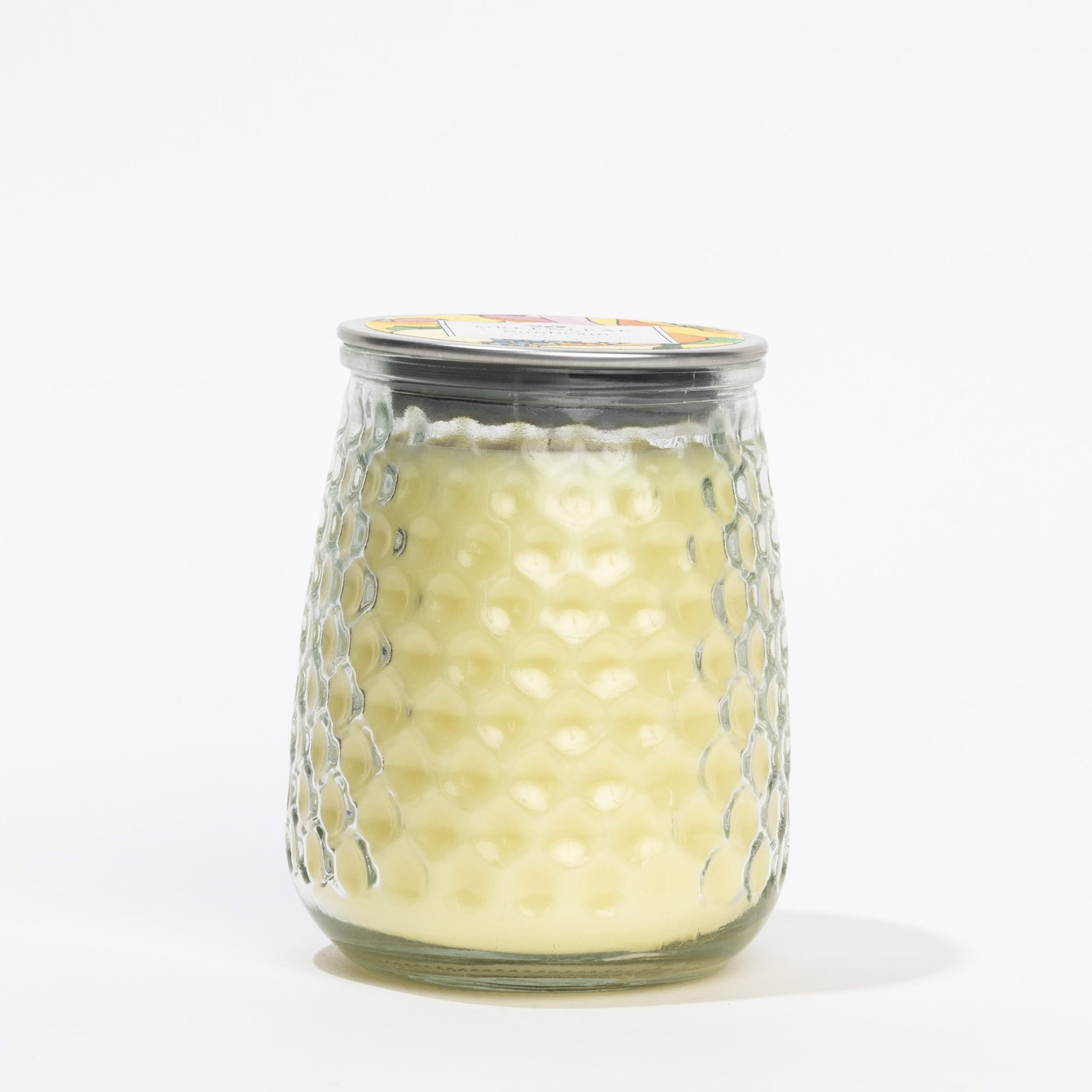 A Greenleaf Gifts Sunbeam Signature Candle in a glass jar with a honeycomb texture, yellowish wax, and a metal lid is displayed on a white background.