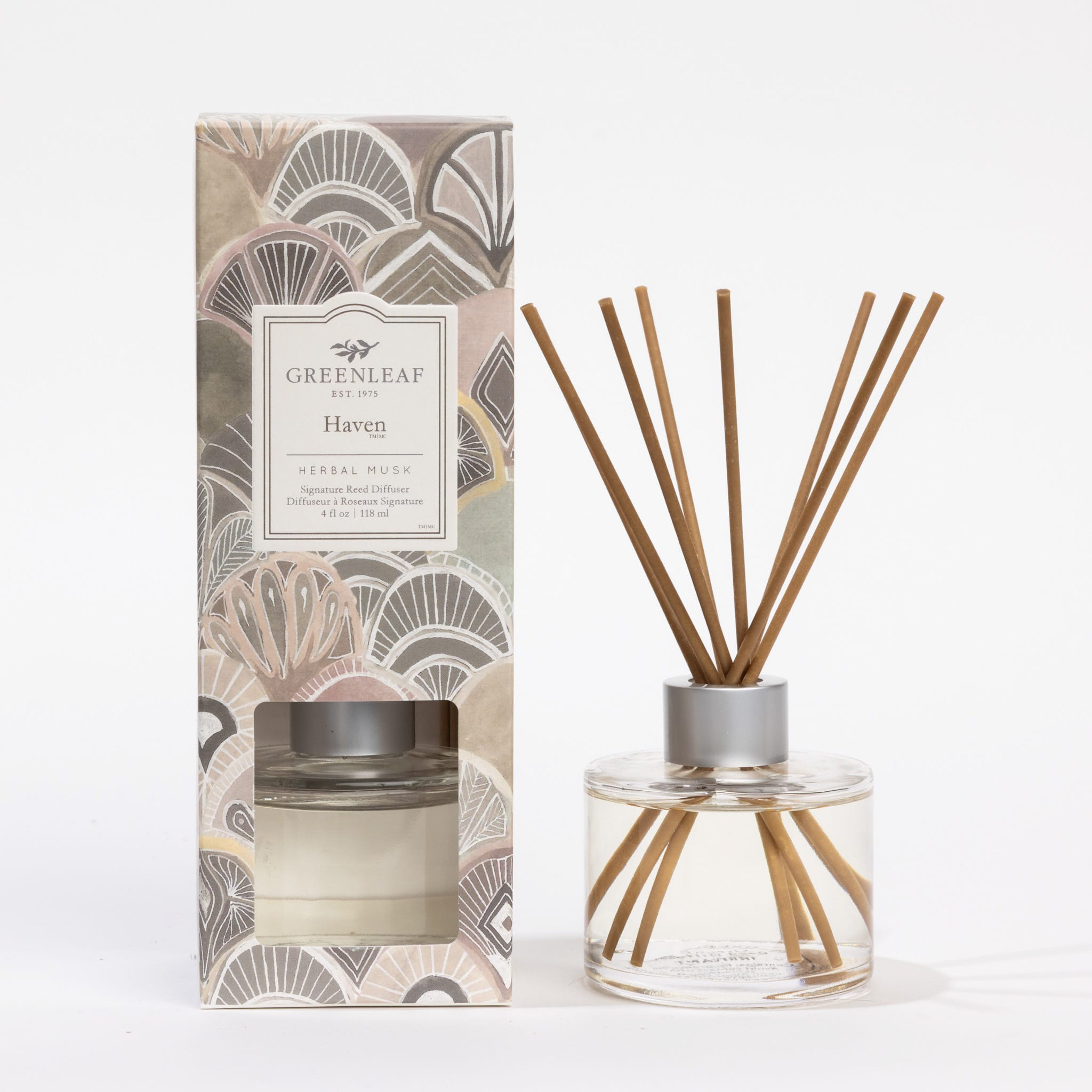 The Greenleaf Gifts Haven Reed Diffuser includes fiber reeds, a glass bottle, and comes in a decorative box with abstract earthy patterns to fill your space with a fresh herbal musk scent.