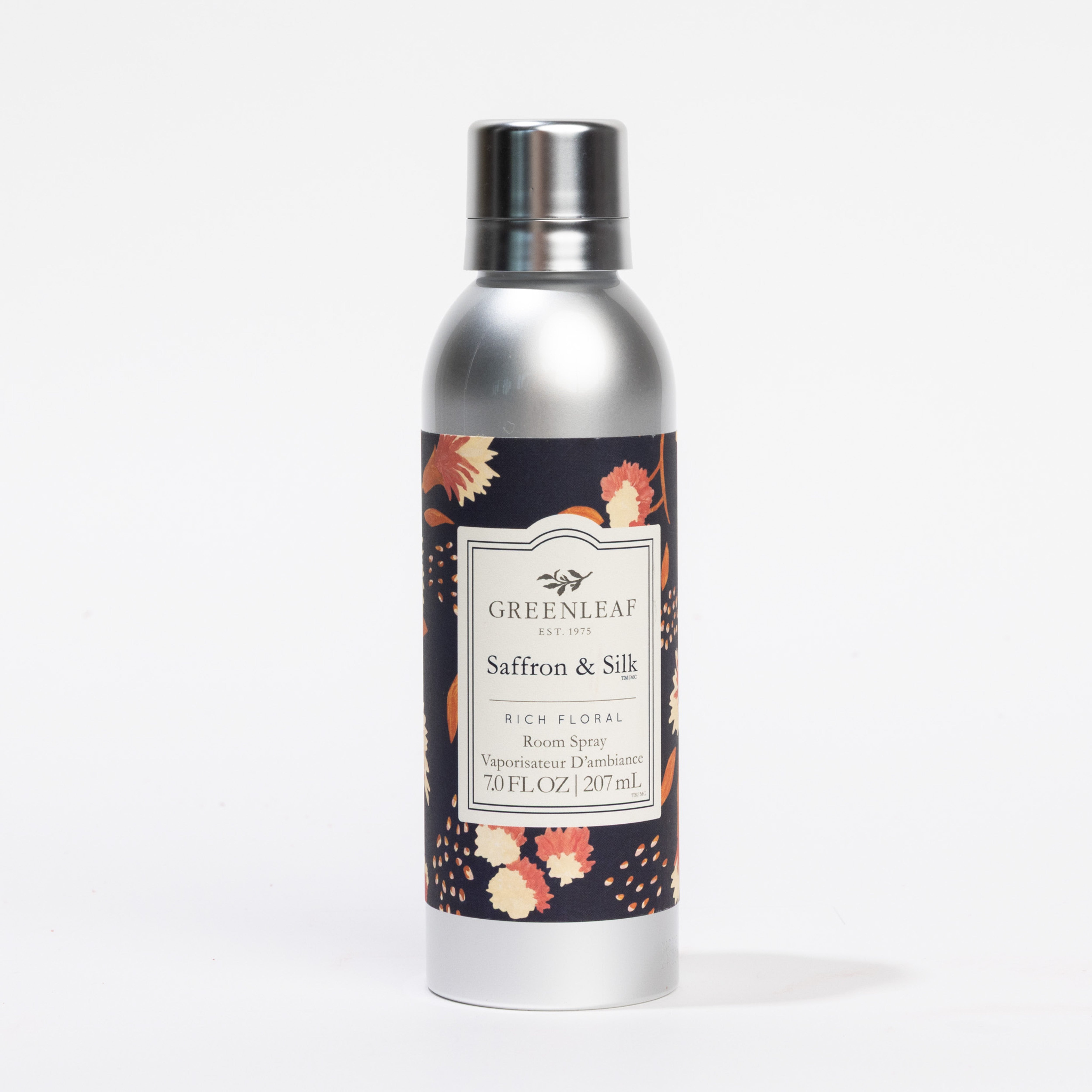 A silver can of Greenleaf Gifts Saffron & Silk Room Spray with a floral-patterned label and metallic cap stands upright against a plain white background.