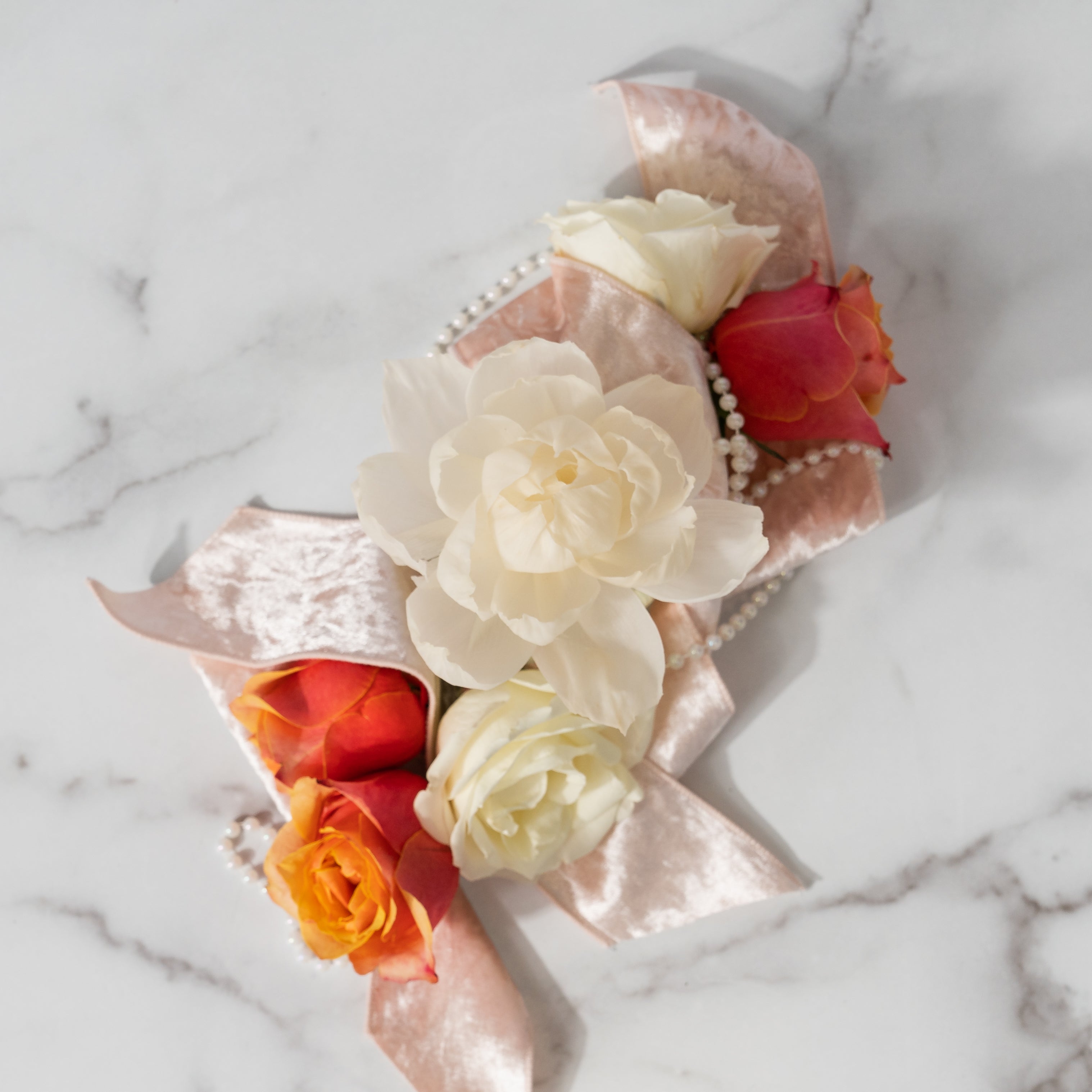The Cashmere Kiss Flower Diffuser by Greenleaf Gifts features white and orange roses, a string of pearls, and a pink velvet ribbon on marble. 8 oz (GLG966522S) with 60 days freshness—perfect for gifting or display.