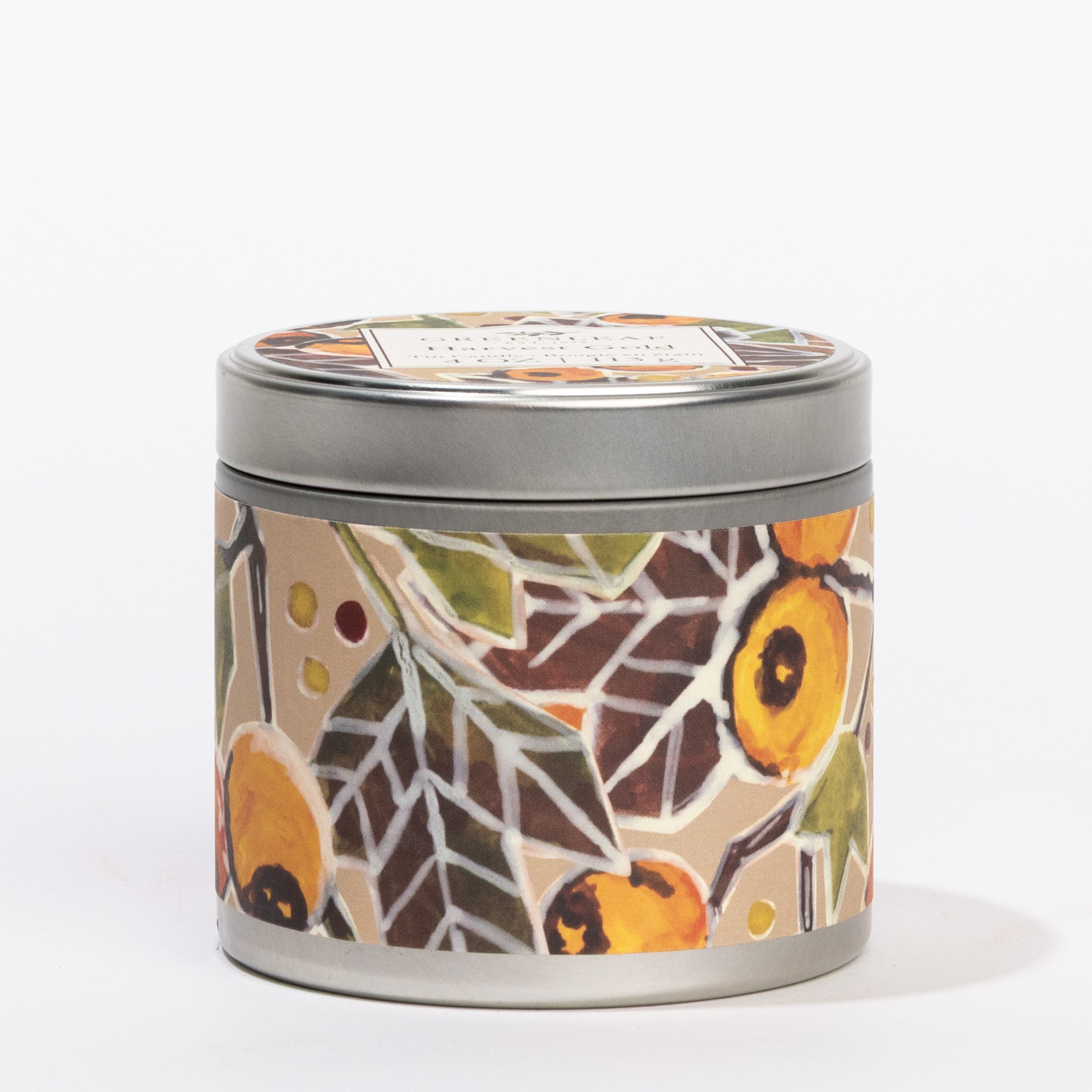 The Harvest Gold Tin Candle by Greenleaf Gifts features a round metal tin with lid, adorned in colorful floral and leaf patterns in gold, orange, green, and brown on beige—a stylish, convenient portable candle topped with a branded label.