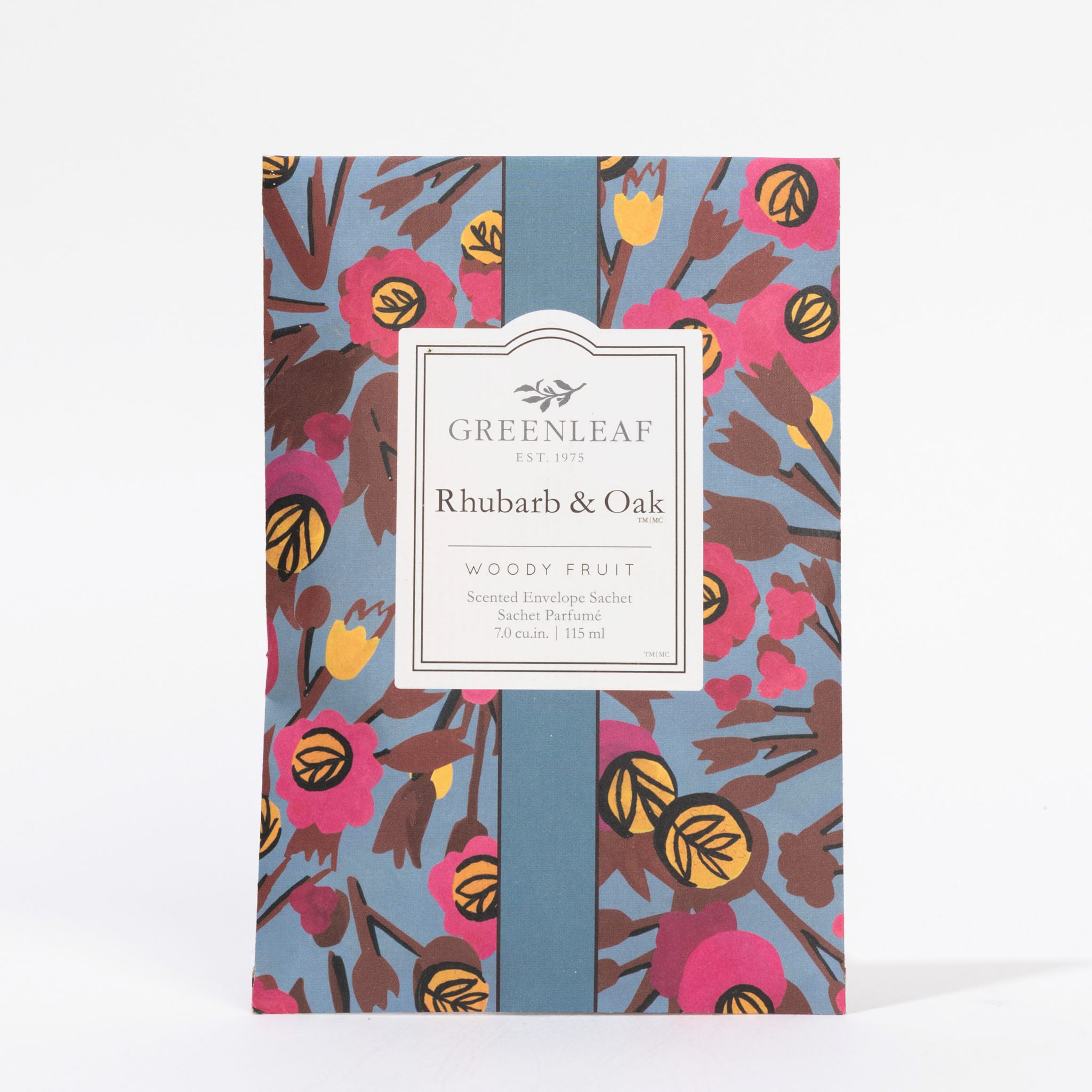 The Greenleaf Gifts Rhubarb & Oak Sachet features a floral and leaf design in pink, yellow, and blue, with a center label describing its long-lasting Woody Fruit fragrance.
