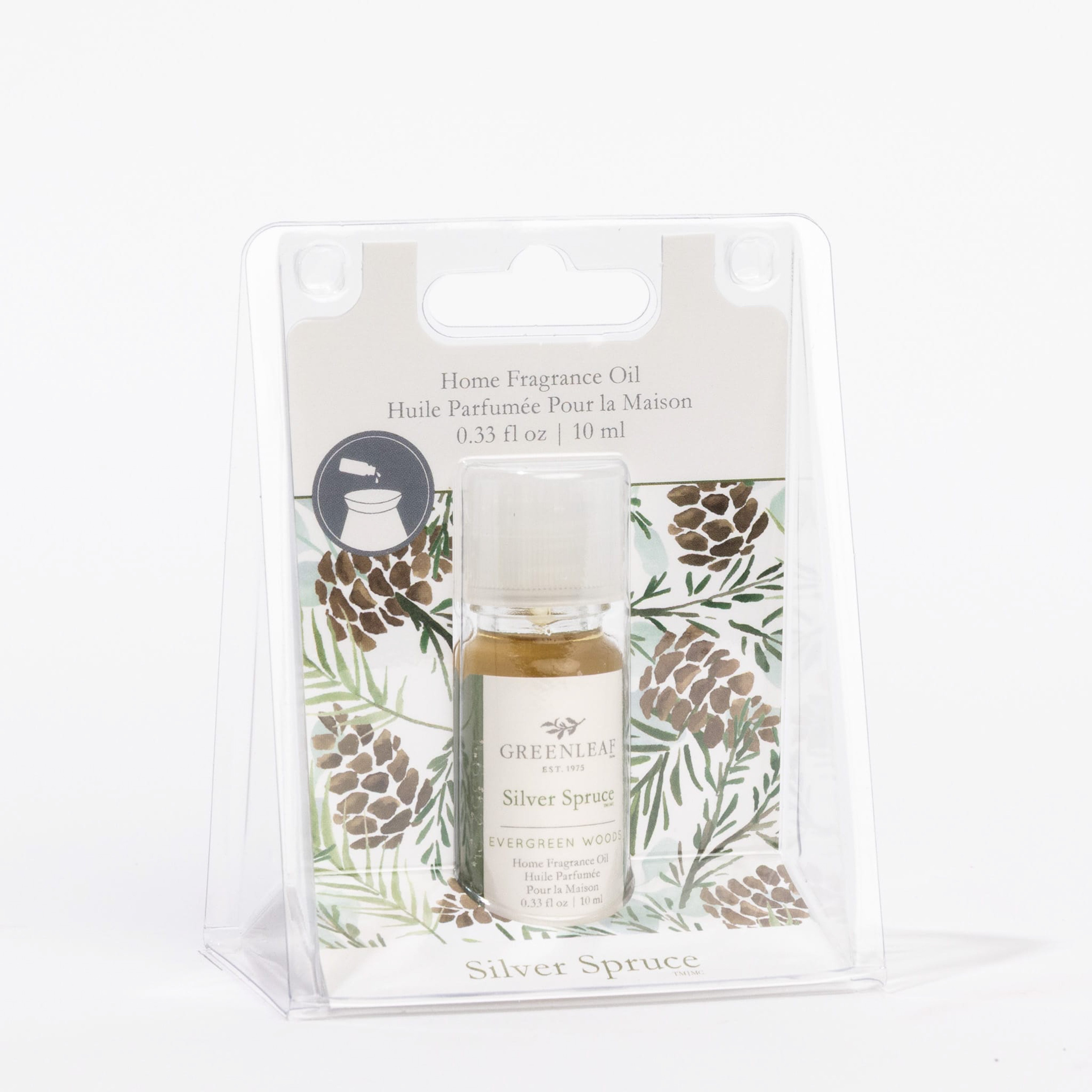 The Greenleaf Gifts Silver Spruce Home Fragrance Oil comes in a small bottle packaged in a clear plastic box with pinecone and evergreen branch accents, offering effortless, flameless scent with visible label and details.