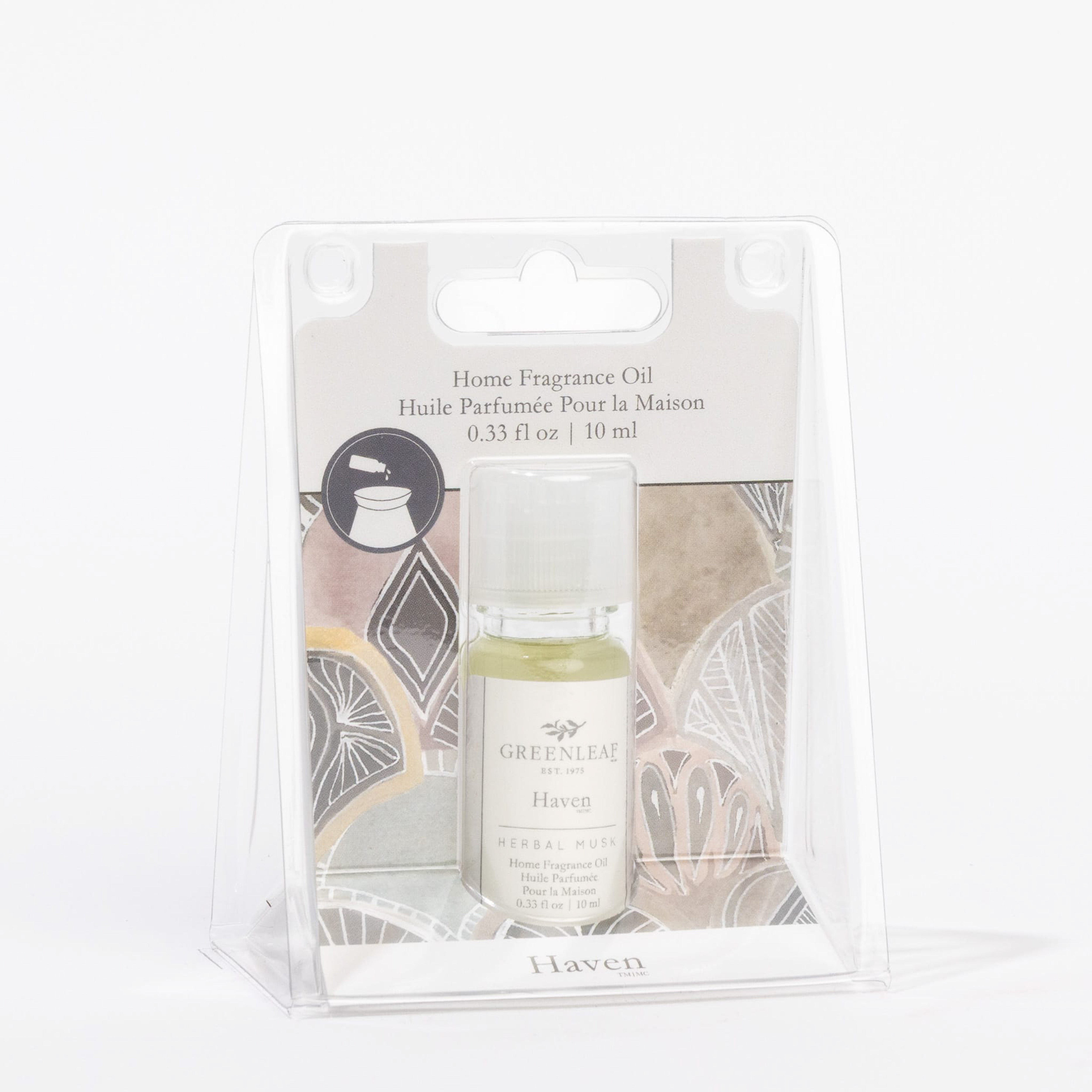 A 10 ml bottle of Greenleaf Gifts Haven Home Fragrance Oil is shown in clear plastic packaging with a pastel background, labeled in English and French, offering a flameless scent experience reminiscent of a seashore breeze.