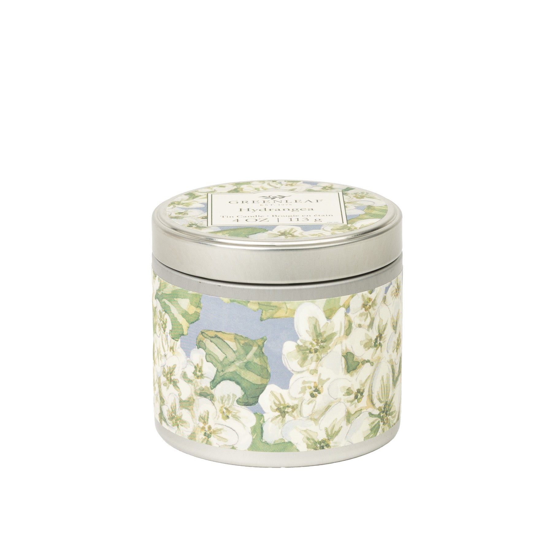The Greenleaf Gifts Hydrangea Tin Candle features a floral design with white flowers and green leaves. Enjoy the refreshing Crisp Leaf Hydrangea scent on the go—perfect as a portable travel candle with a secure lid.