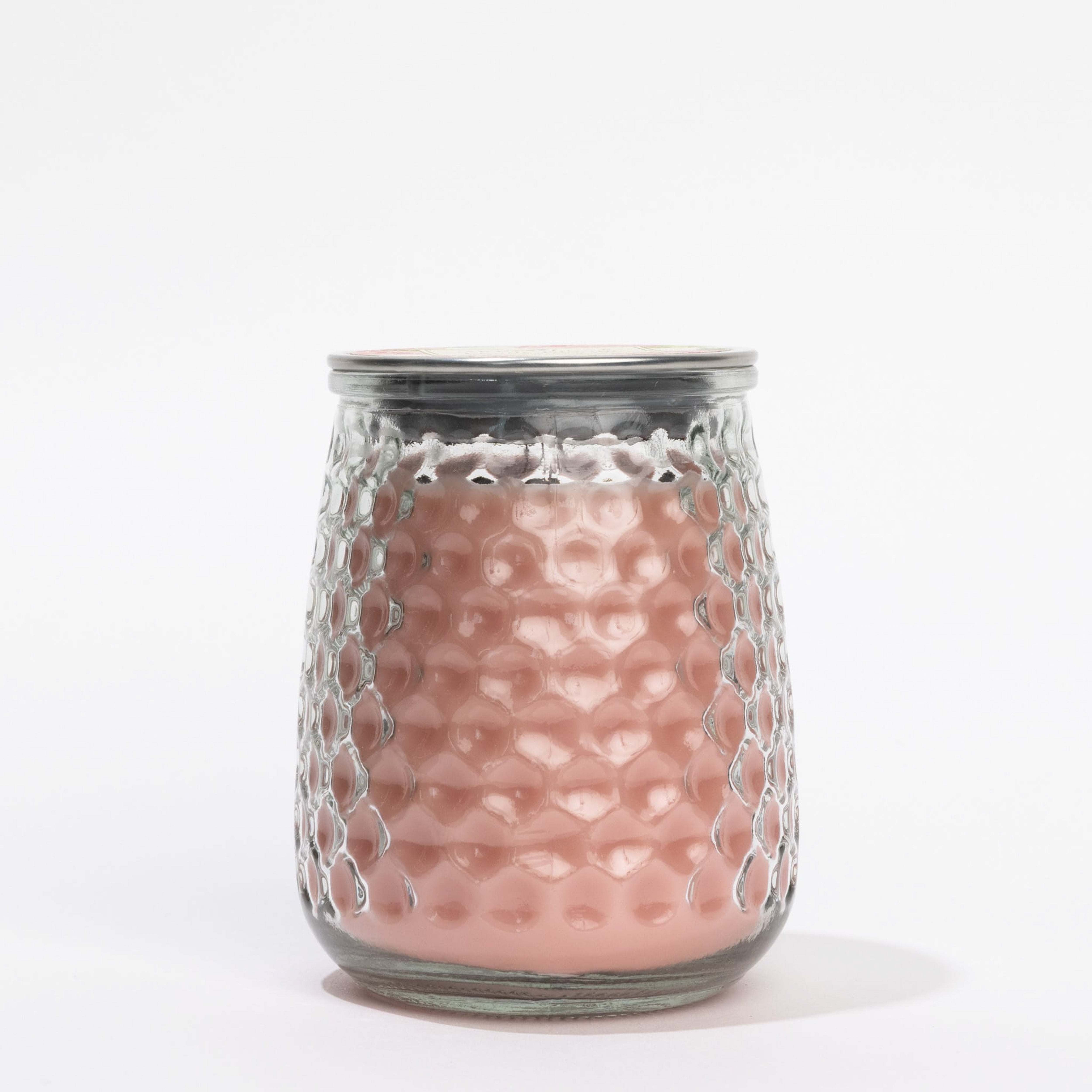 The Peony Bloom Signature Candle from Greenleaf Gifts features pink wax in a glass jar with a honeycomb texture and silver lid, displayed against a plain white background.