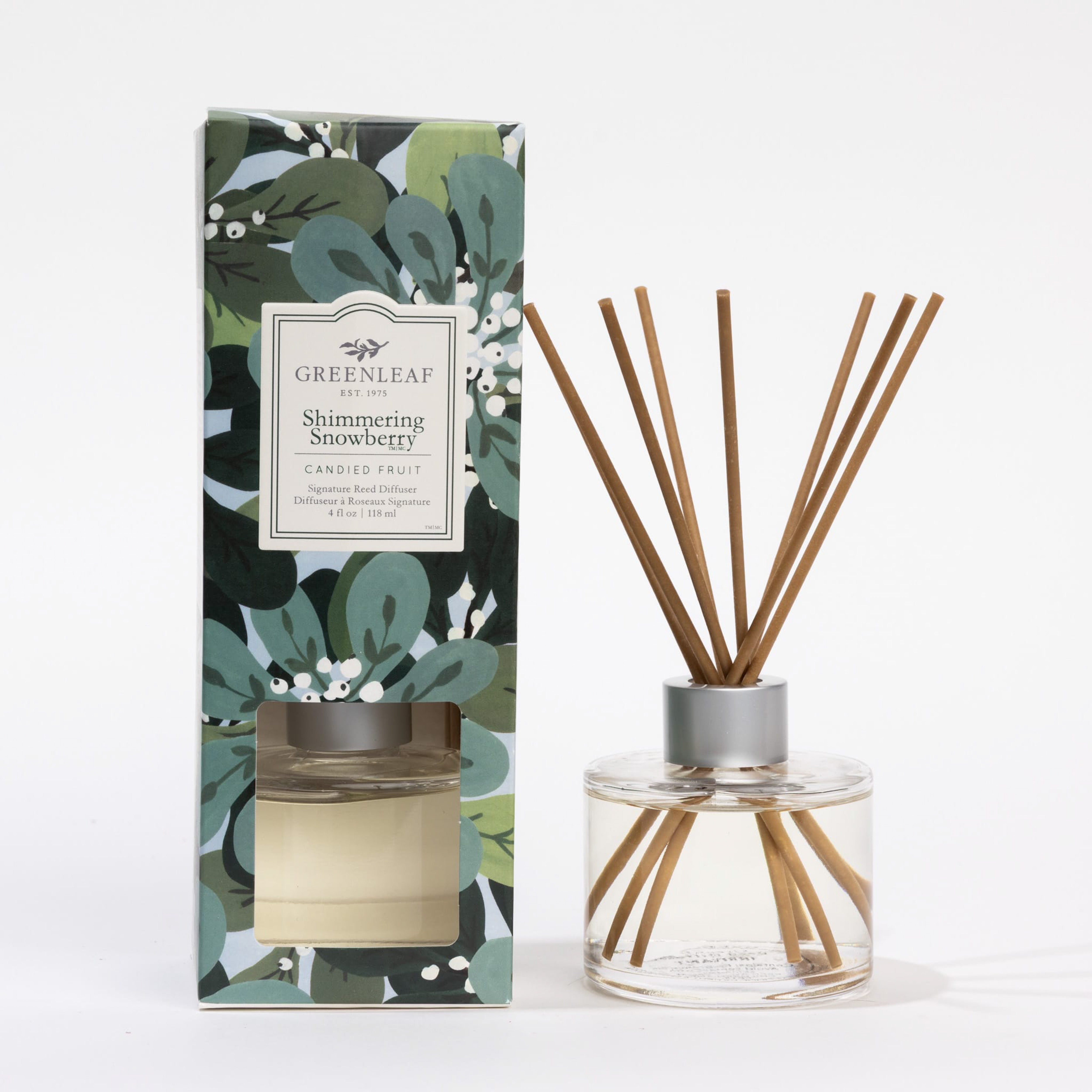 The Greenleaf Gifts Shimmering Snowberry Reed Diffuser set includes a floral-patterned box, a clear glass fragrance bottle, and fiber reeds for a long-lasting scent.