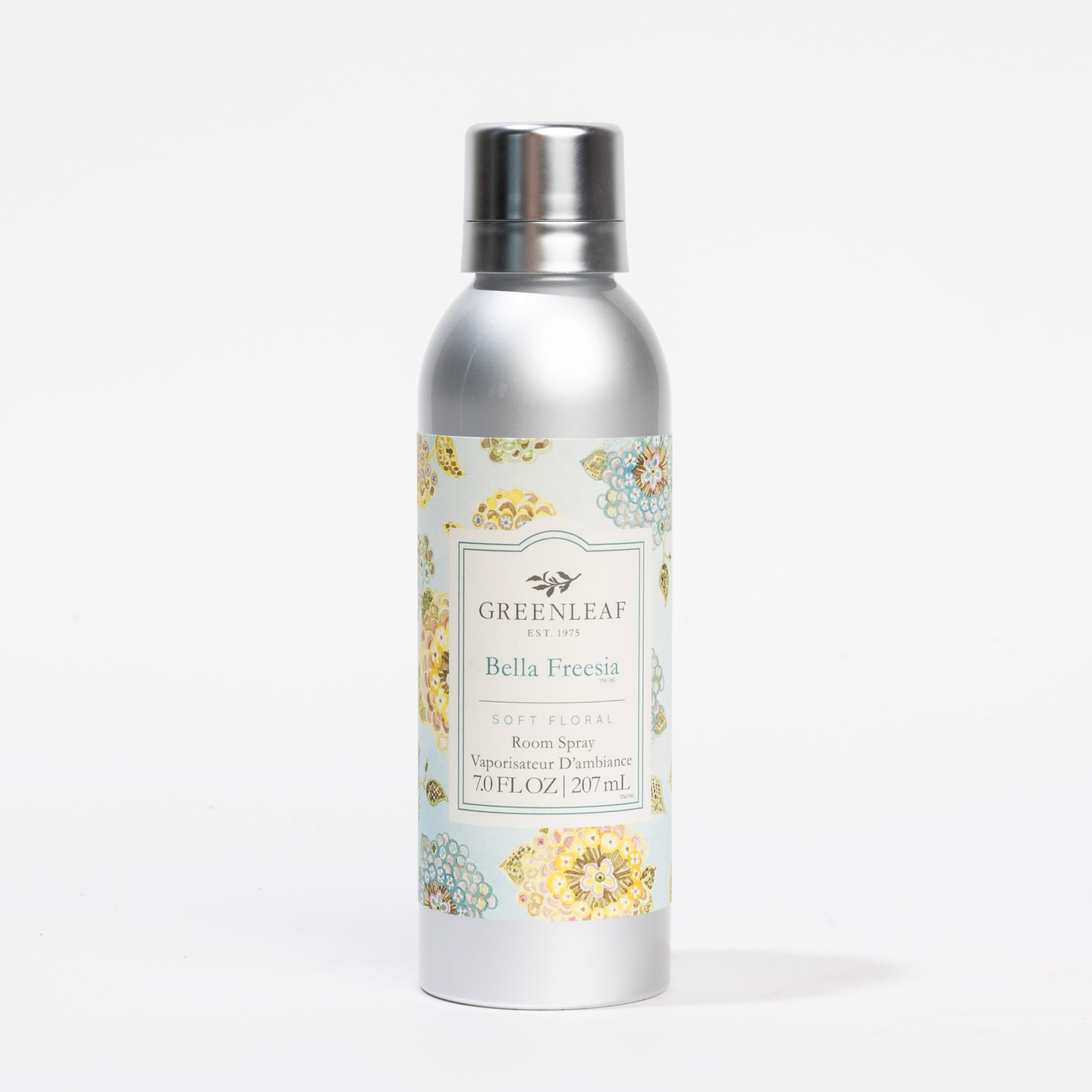 A silver can of Greenleaf Gifts Bella Freesia Room Spray features a floral-patterned label with yellow and blue flowers, and displays product details in elegant fonts on a crisp white background.
