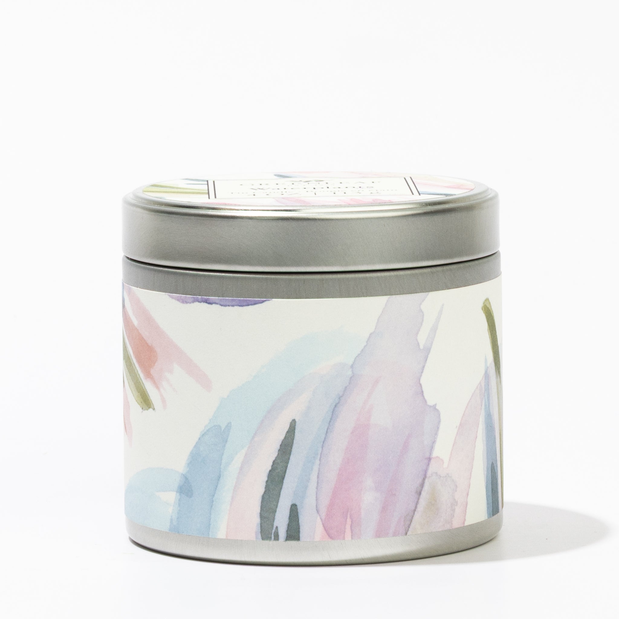 The Greenleaf Gifts Waterplants Tin Candle features a pastel watercolor design in pink, blue, purple, and green on a round metal tin with lid, offering a soothing waterplants fragrance for a relaxing and portable candle experience.