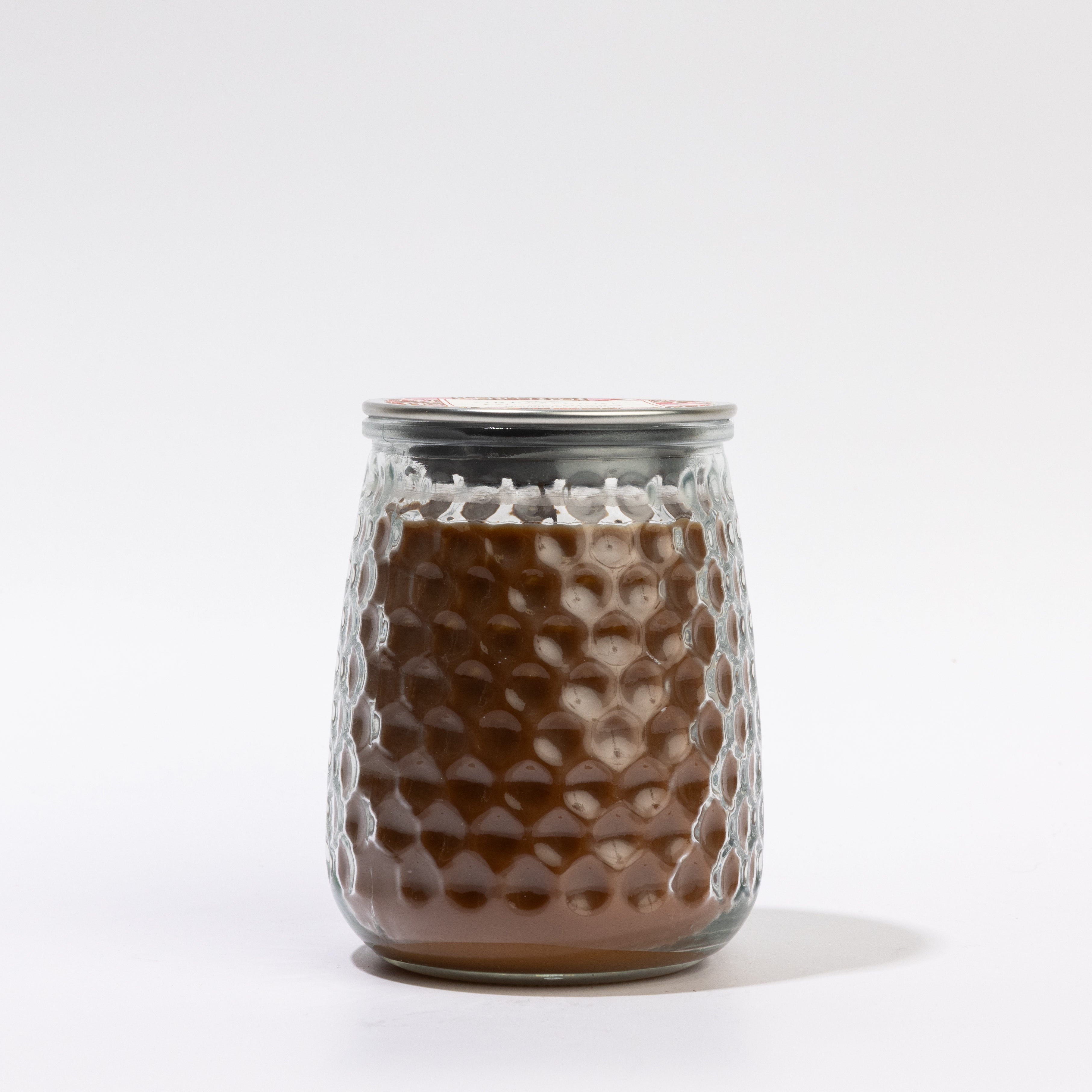 The Greenleaf Gifts Gingerbread Signature Candle (GLG915585S) is a 13 oz textured glass jar with brown wax, a honeycomb pattern, and metallic lid. It offers 90–100 hours of burn time and appears against a white background.