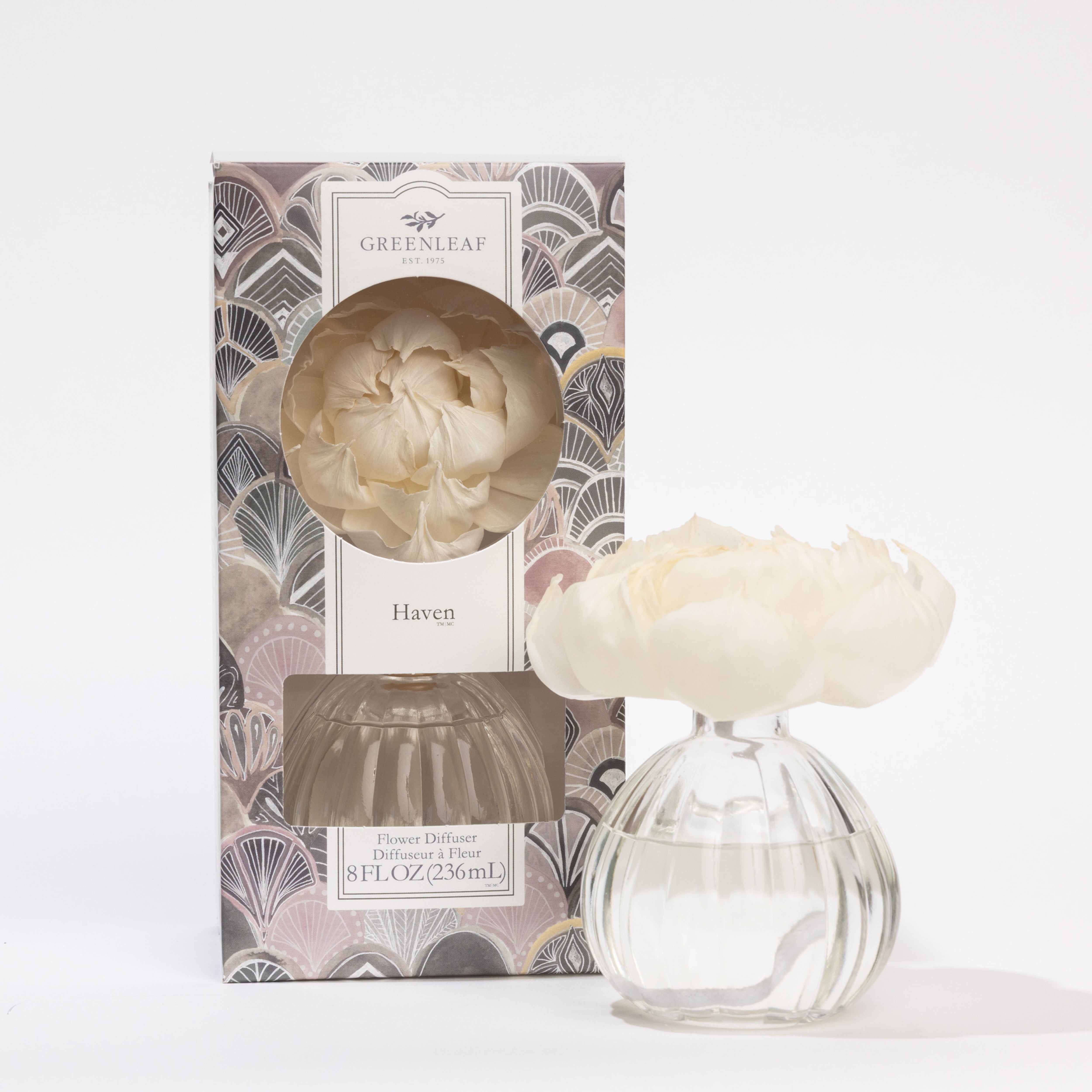 The Greenleaf Gifts Haven Flower Diffuser features a white artificial flower on a round glass bottle with fragrance, sized 4.5x3.5x9.0 inches, lasting up to 60 days, and comes in a decorative box against a white background.