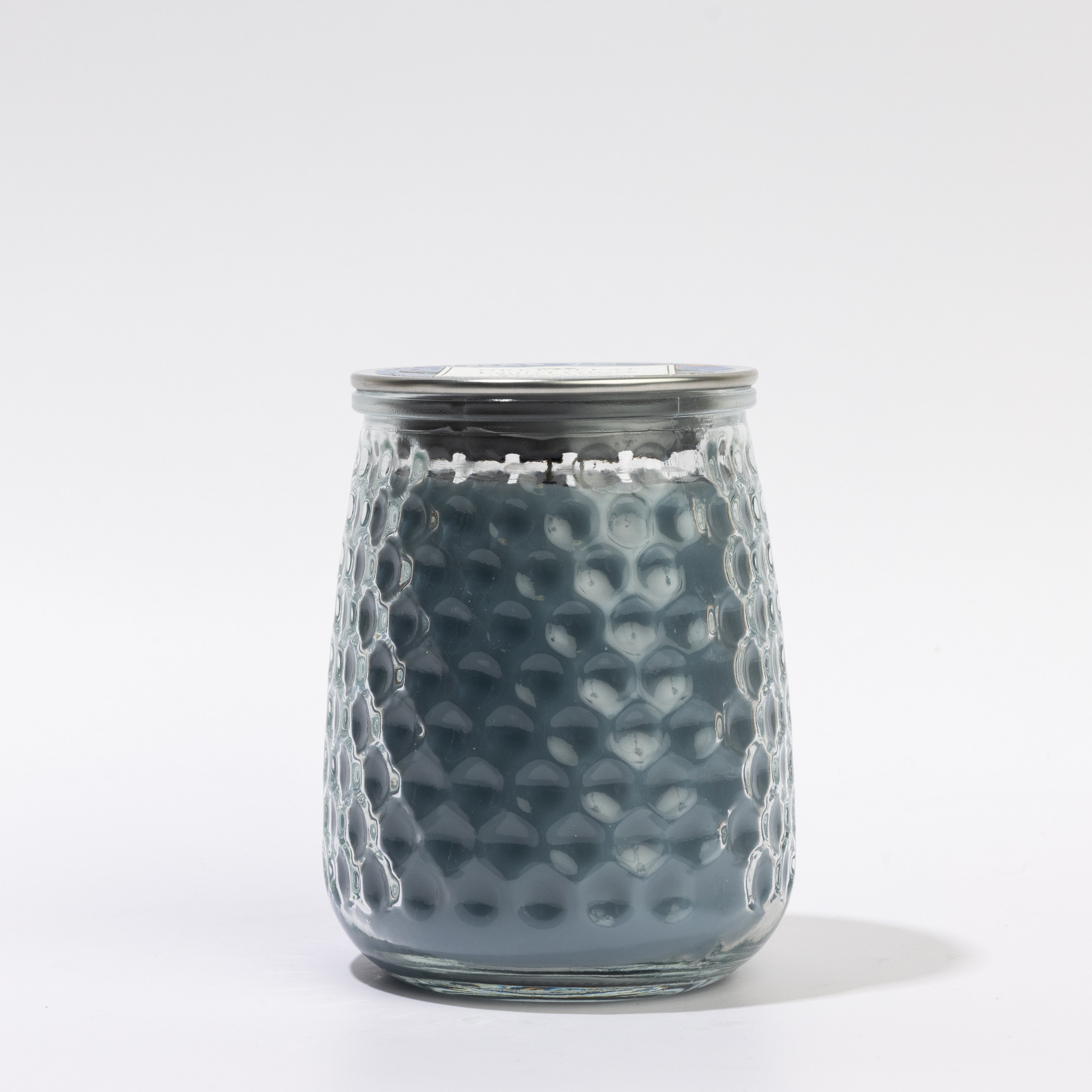 A Greenleaf Gifts Laurel Grove Signature Candle—13 oz, dark gray, in a textured transparent glass jar with a silver lid. Enjoy 90–100 hours of fragrance. Photographed against a plain white background.