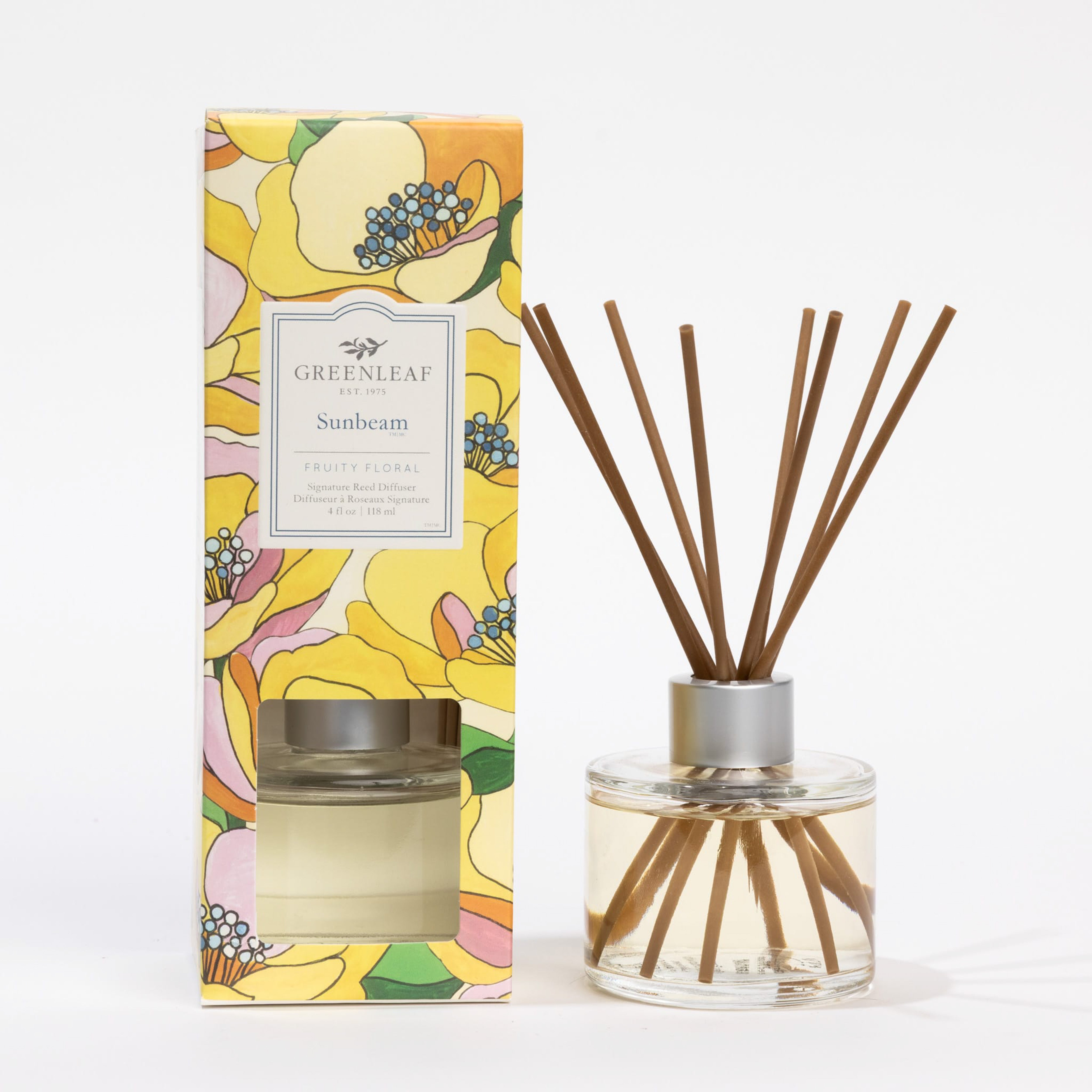 The Greenleaf Gifts Sunbeam Reed Diffuser features a clear glass bottle with fiber reeds and a fresh scent, presented in a floral-patterned box, all displayed against a white background.