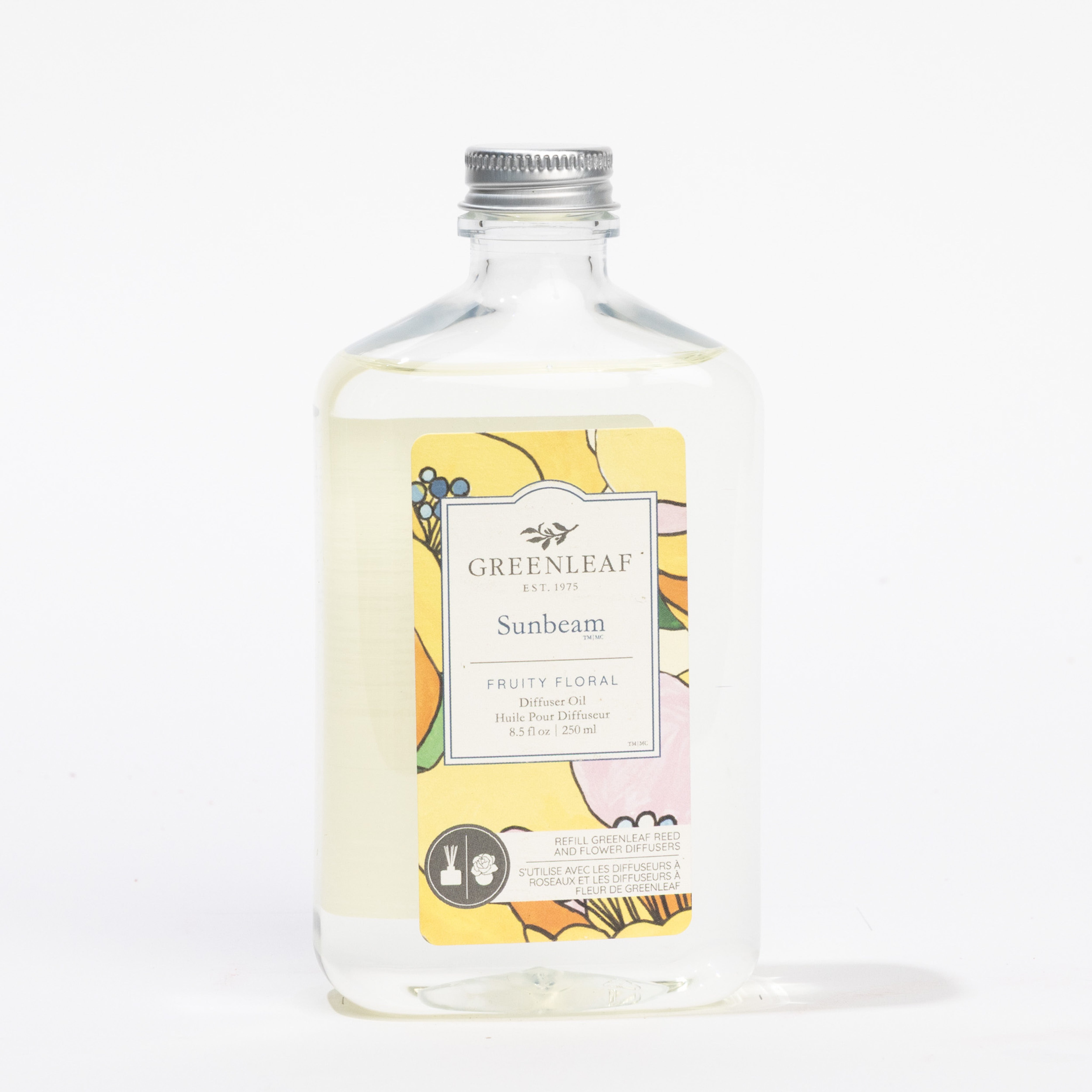 A clear rectangular bottle of Greenleaf Gifts Sunbeam Diffuser Refill Oil with a silver cap. The label features colorful floral art and describes the fragrance as Fruity Floral. The bottle is displayed against a white background.
