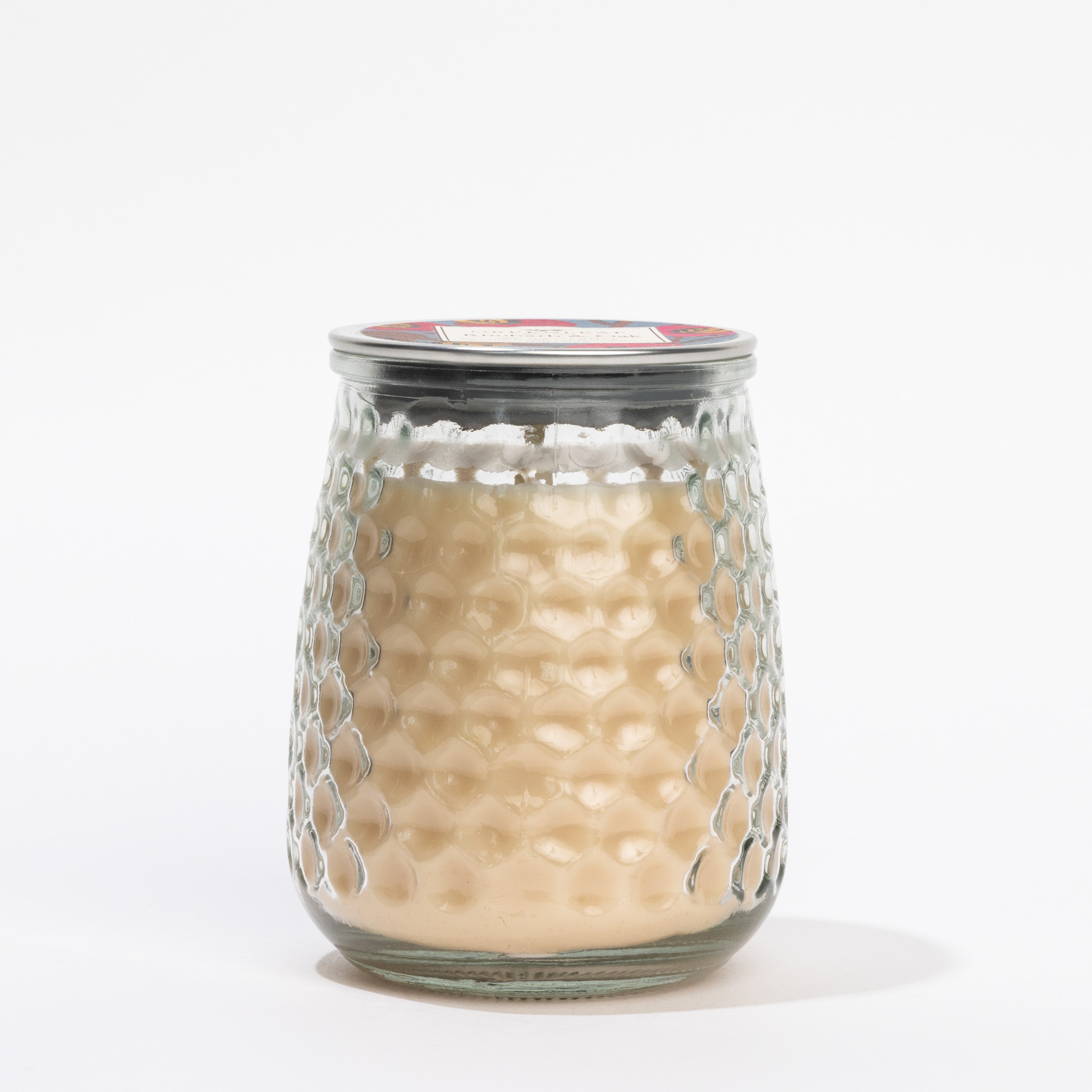The Greenleaf Gifts Rhubarb & Oak Signature Candle is a light tan candle in a glass jar with a honeycomb texture, finished with a metal lid and displayed against a white background.