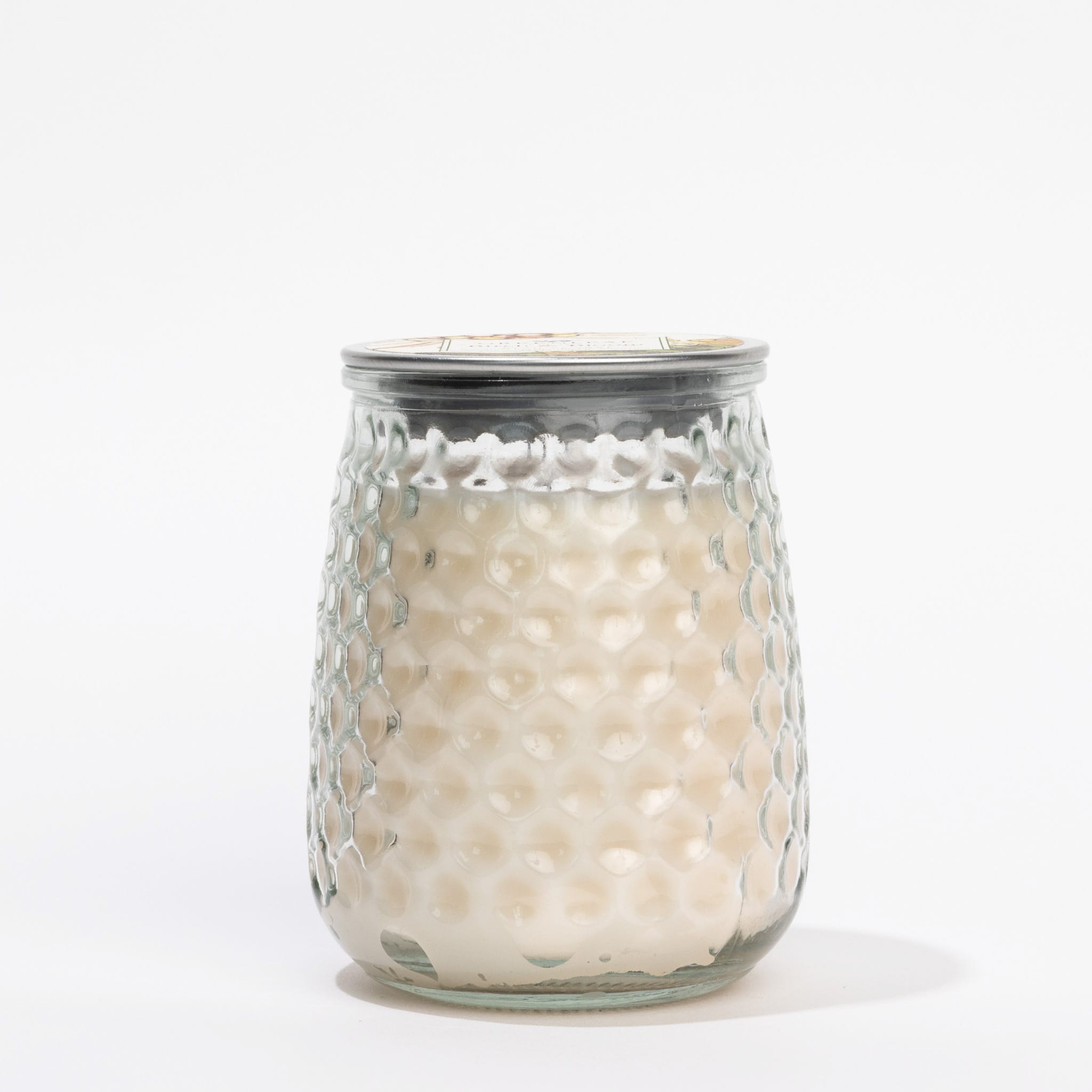 The Birch & Bloom Signature Candle by Greenleaf Gifts features white wax in a honeycomb-textured glass jar with a metal lid, shown against a plain white background.