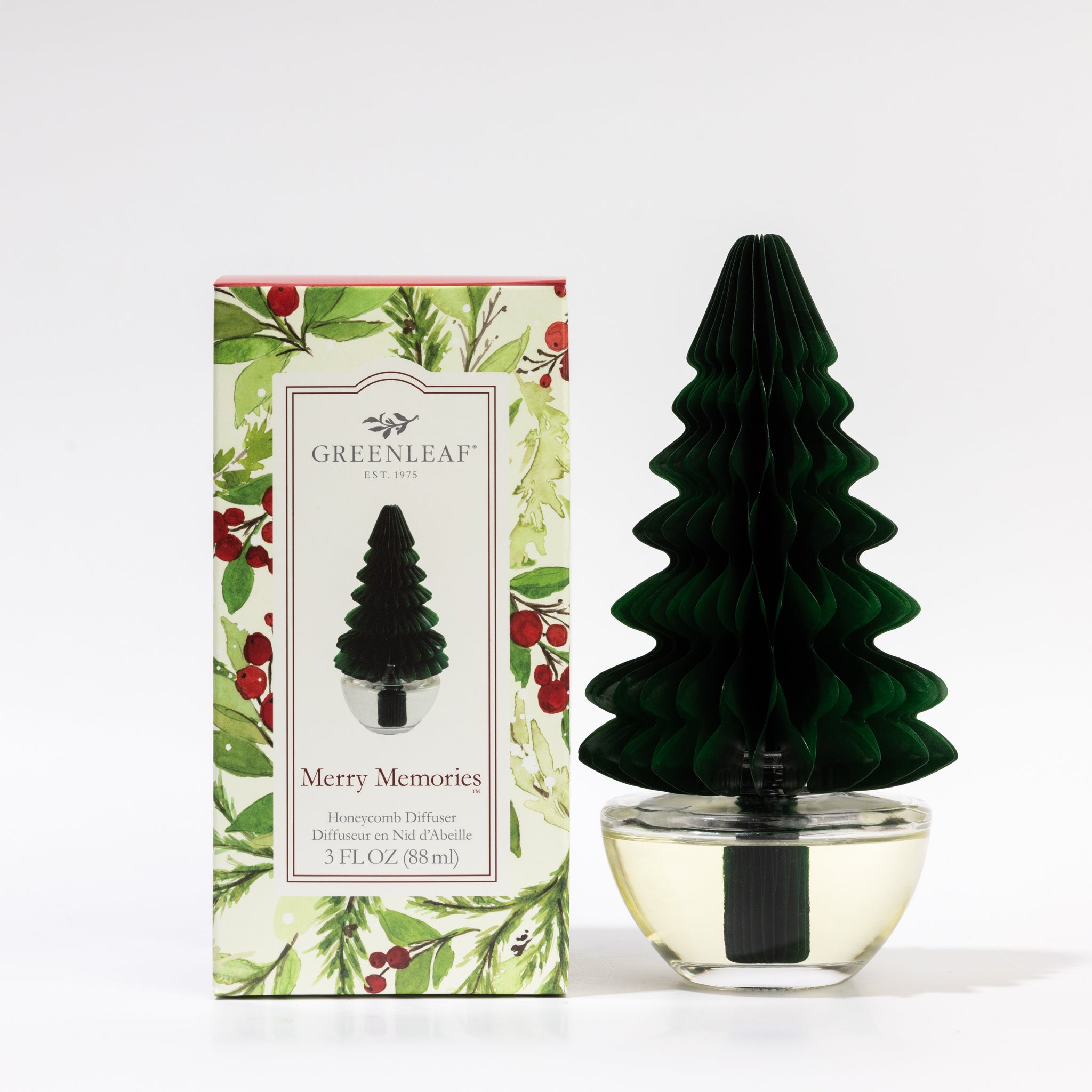 The Greenleaf Gifts Merry Memories Tree Honeycomb Diffuser features a green honeycomb tree topper and comes in a festive holly and berry box. The clear liquid inside releases classic holiday scents from Greenleaf Gifts.