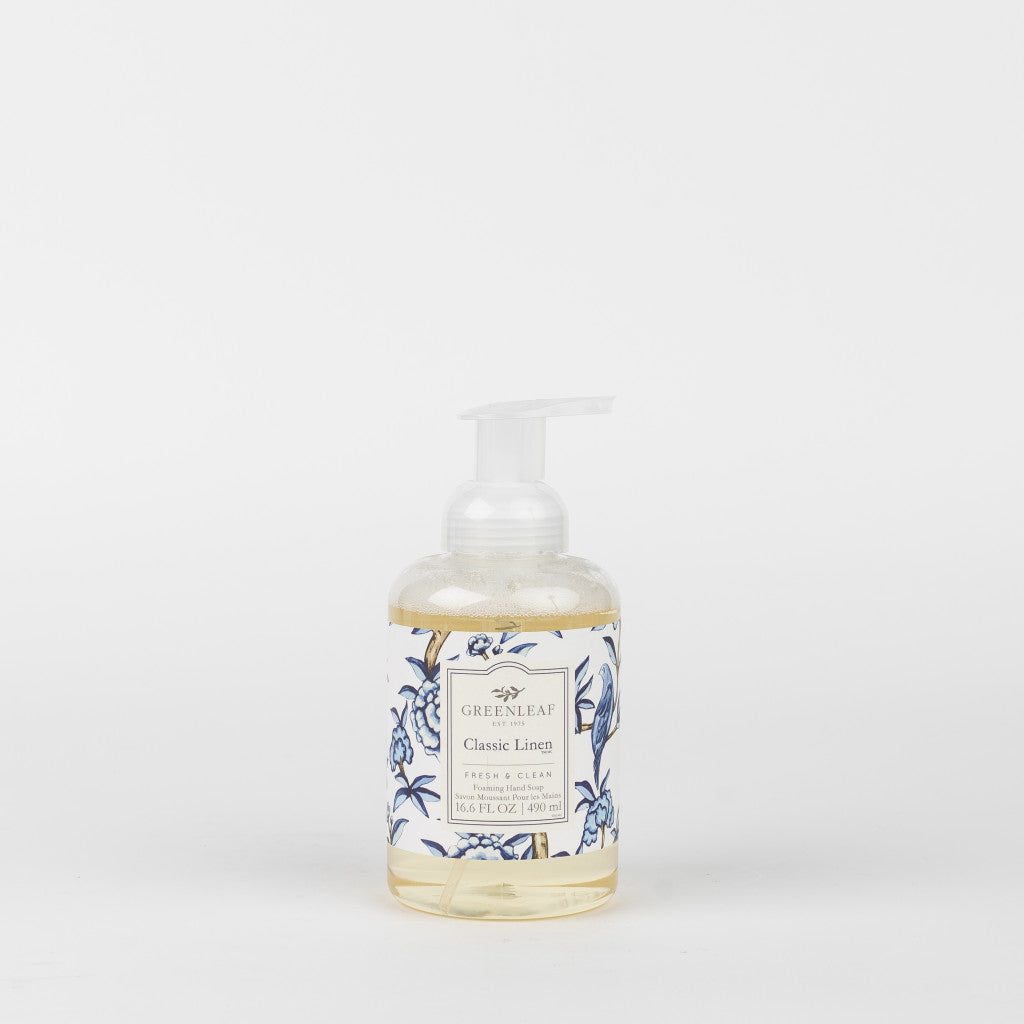 A clear pump bottle of Greenleaf Gifts Classic Linen Foaming Hand Soap, featuring a white and blue floral label and enriched with coconut oil, displayed against a plain white background.