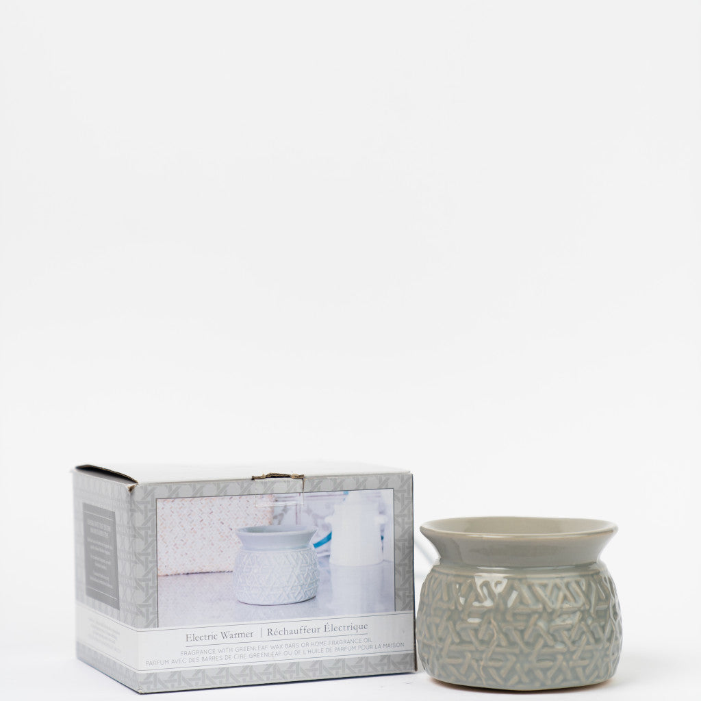 The Greenleaf Gifts Warmer-Grey Round, a ceramic wax warmer with a geometric design, is shown beside its box featuring the warmer in use—ideal for your favorite fragrance oils or wax melts.