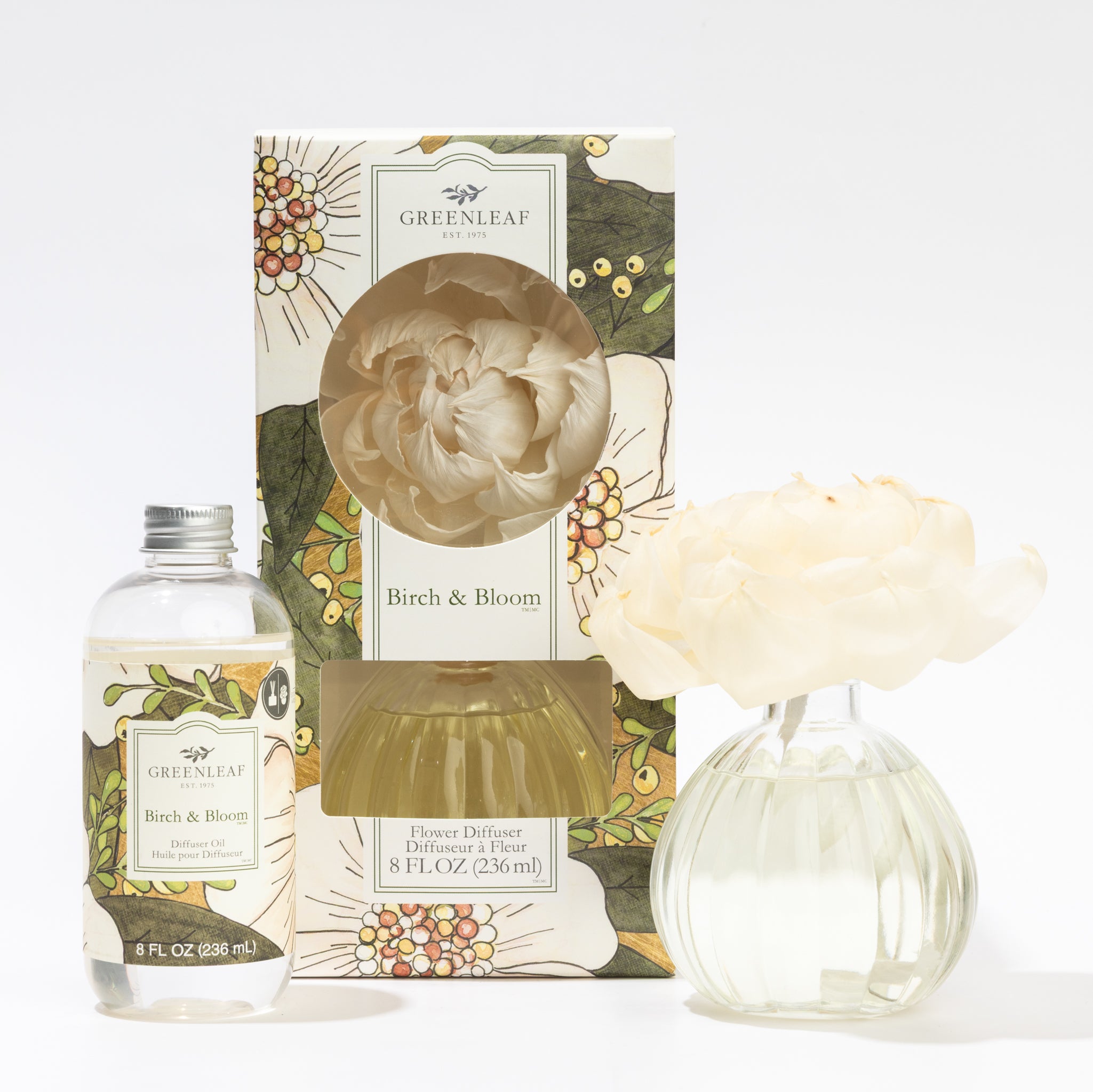 The Fast Bundle Birch & Bloom Flower Diffuser & Refill Oil set includes a clear fragrance oil bottle, a floral-decorated box, and a vase with a cream-colored flower—ideal for refreshing your space with delightful scents.