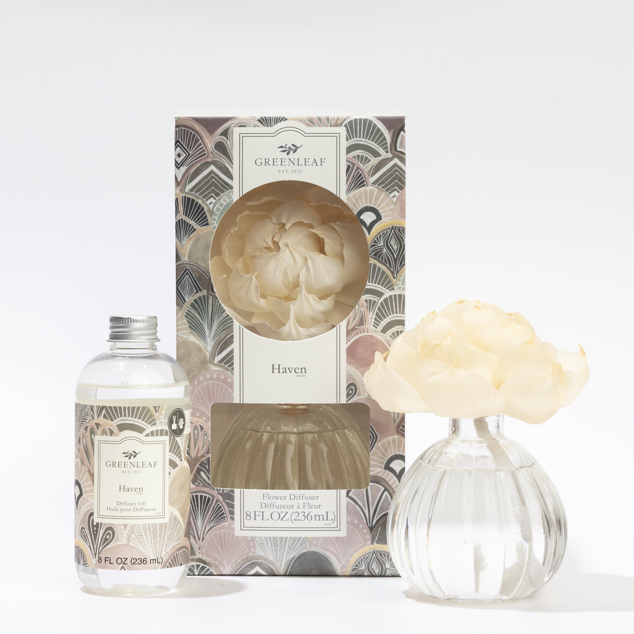 The Fast Bundle Haven Flower Diffuser & Fragrance Oil Refill set includes a stylish art deco box, a clear refill bottle with Haven fragrance oil, and a glass vase topped with a cream flower for elegant scent diffusion.