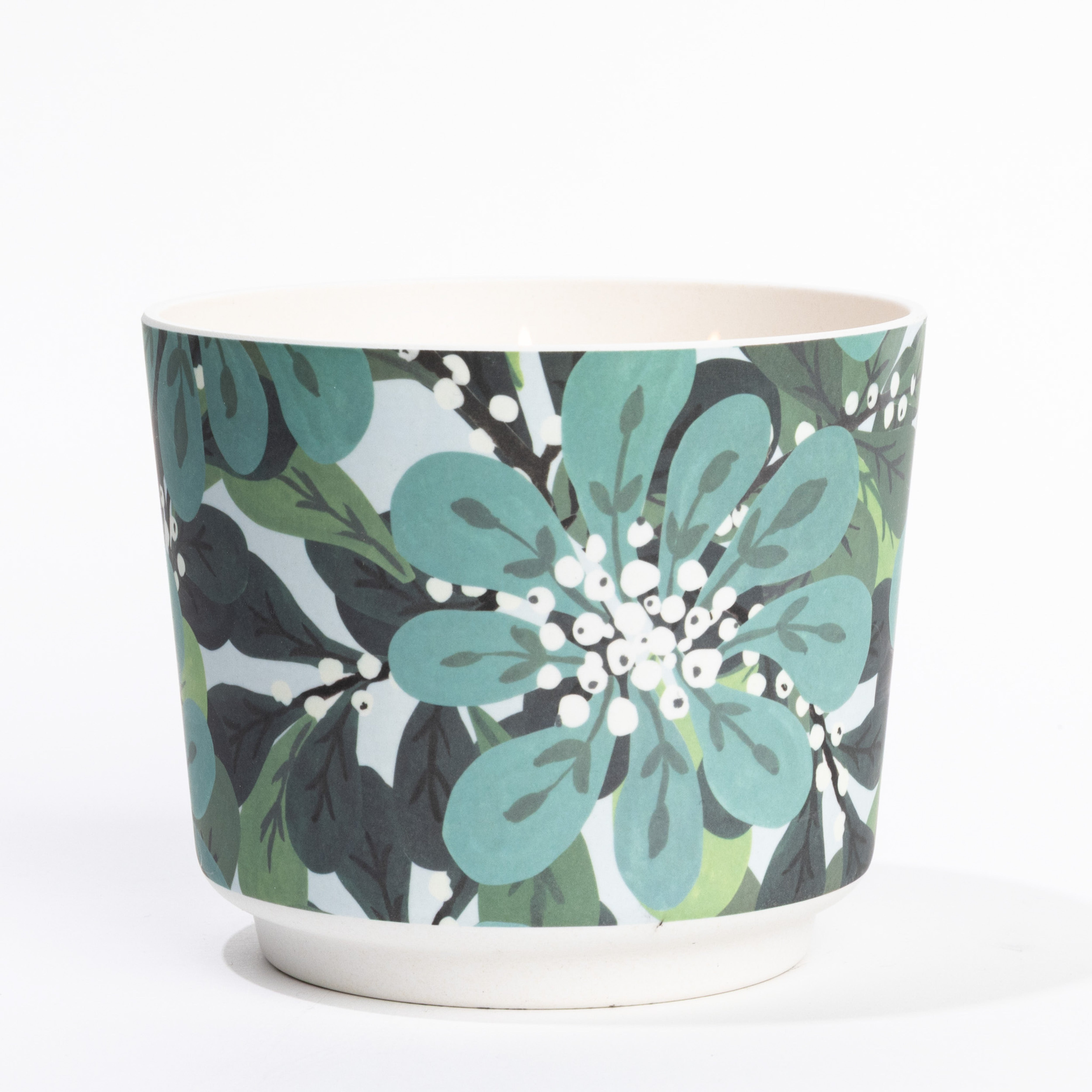 The Shimmering Snowberry Patterned 3 Wick Candle by Greenleaf Gifts features a vibrant floral design with bold blue and green flowers, accented in white on a white background, similar to the pattern seen on ceramic cups. Photographed on a plain white surface.