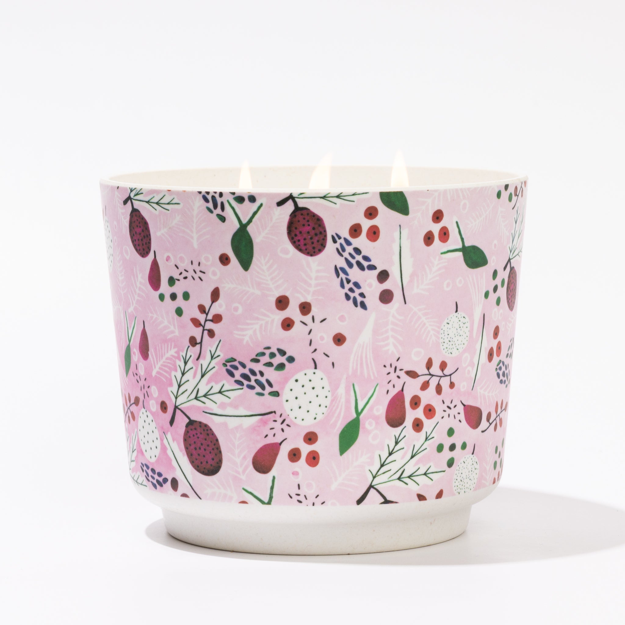 The Brambleberry Patterned 3 Wick Candle by Greenleaf Gifts features a round container with a pink, botanical design. When lit, its three flames fill the air with a delightful brambleberry fragrance.