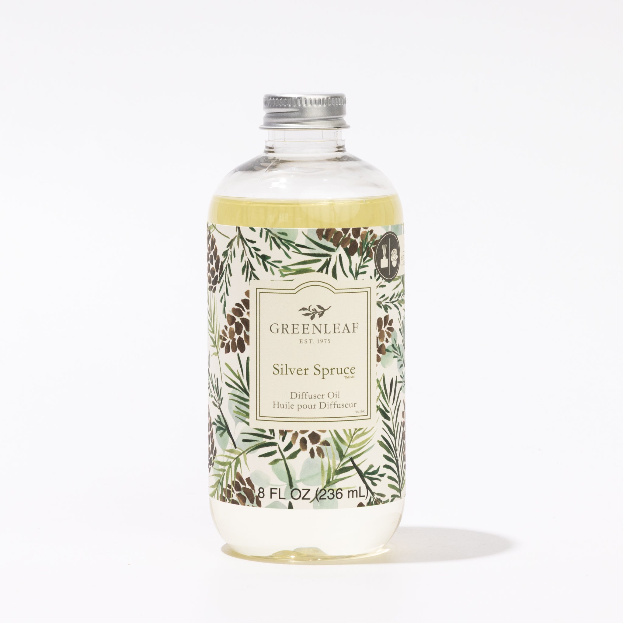 A clear 236 ml (8 fl oz) bottle of Greenleaf Gifts Silver Spruce Diffuser Oil features a silver cap and a label with botanical pine cone and evergreen art. This Flower Diffuser Refill oil brings fresh fragrance to your space.