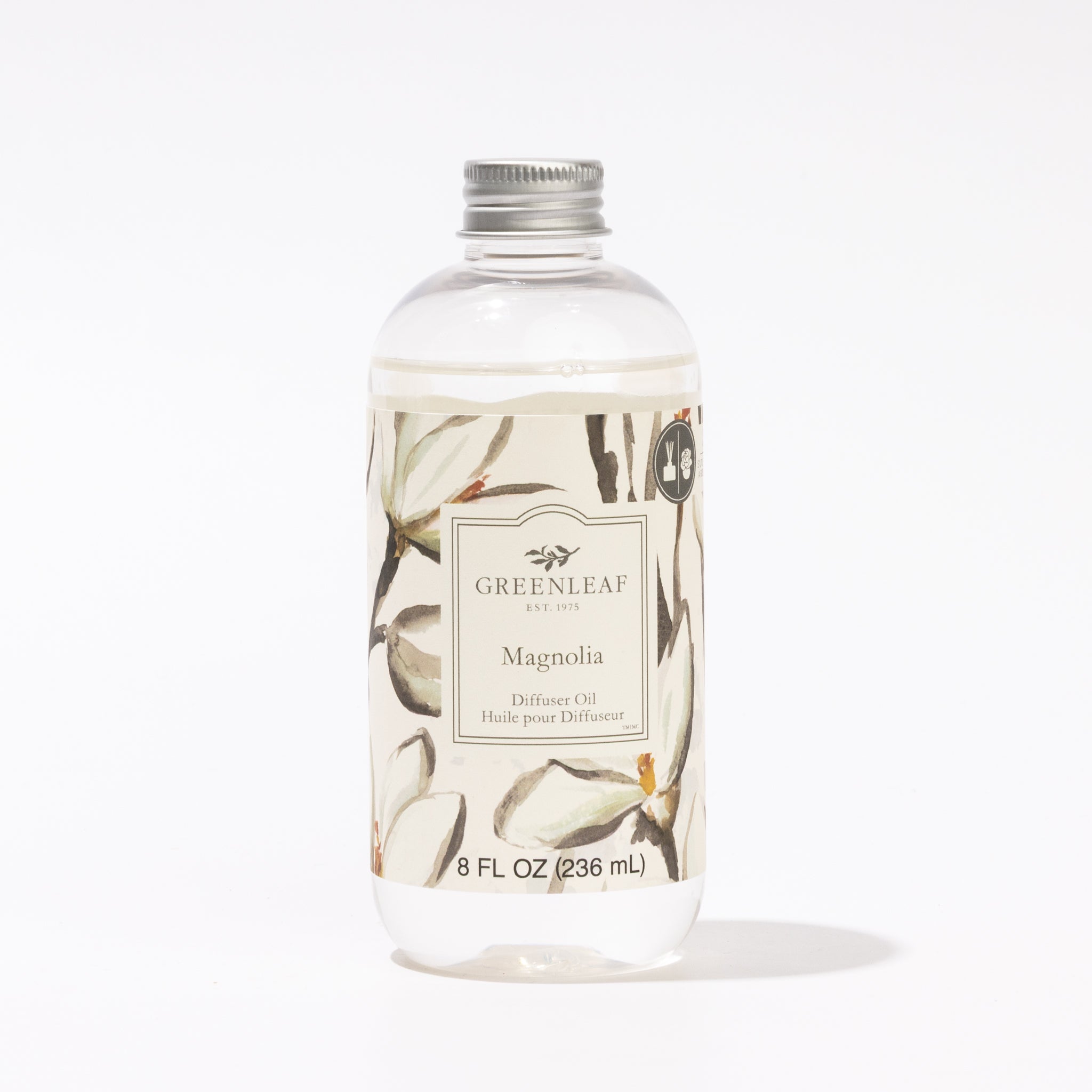 A clear plastic bottle with a silver cap contains Greenleaf Gifts Magnolia Diffuser Oil. The label displays magnolia flowers and bilingual text. This refill holds 8 fl oz (236 ml) of refreshing Magnolia fragrance.