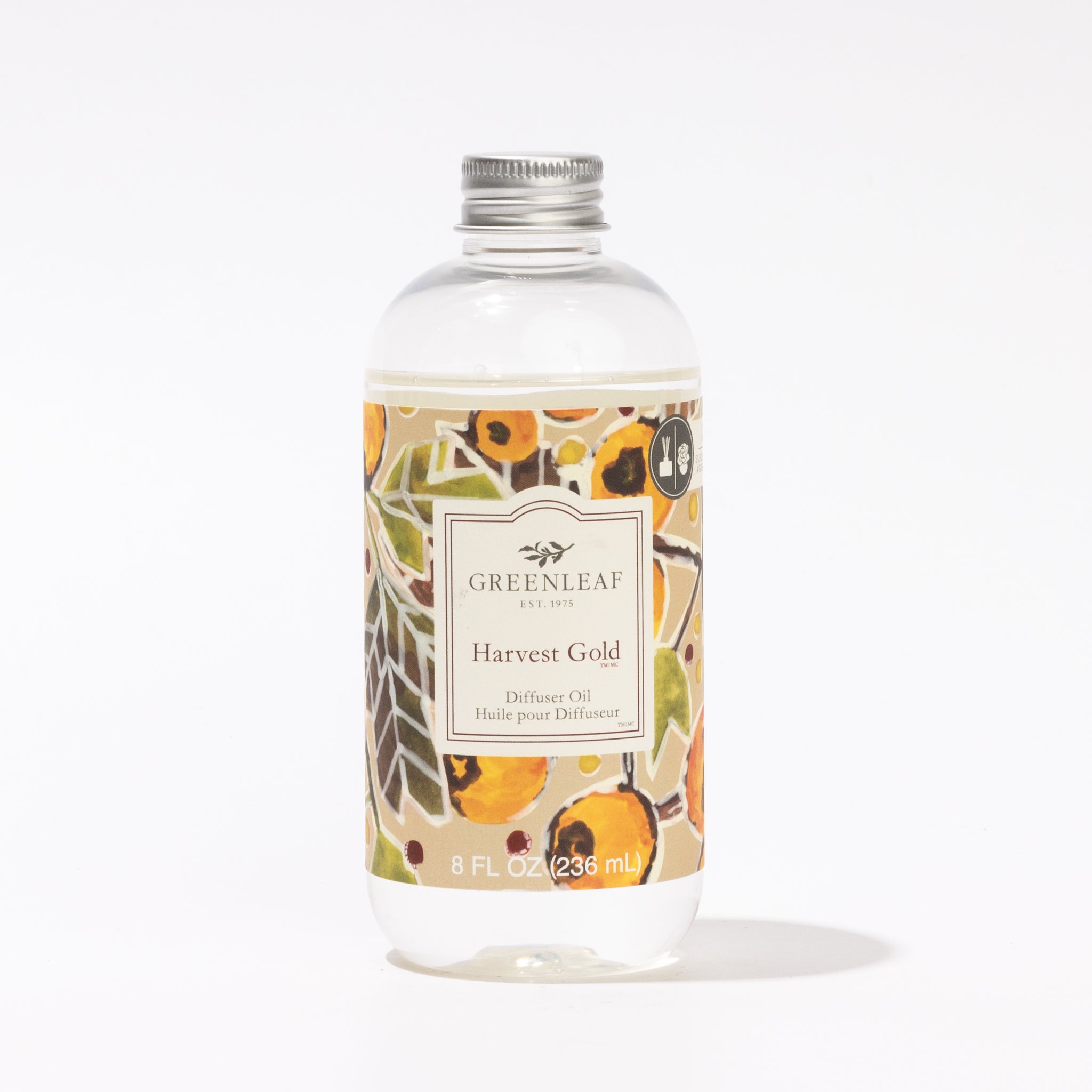 A clear bottle of Greenleaf Gifts Harvest Gold Diffuser Oil, featuring a silver cap and an autumn-themed label, ideal as a Reed Diffuser Refill, displayed against a white background.
