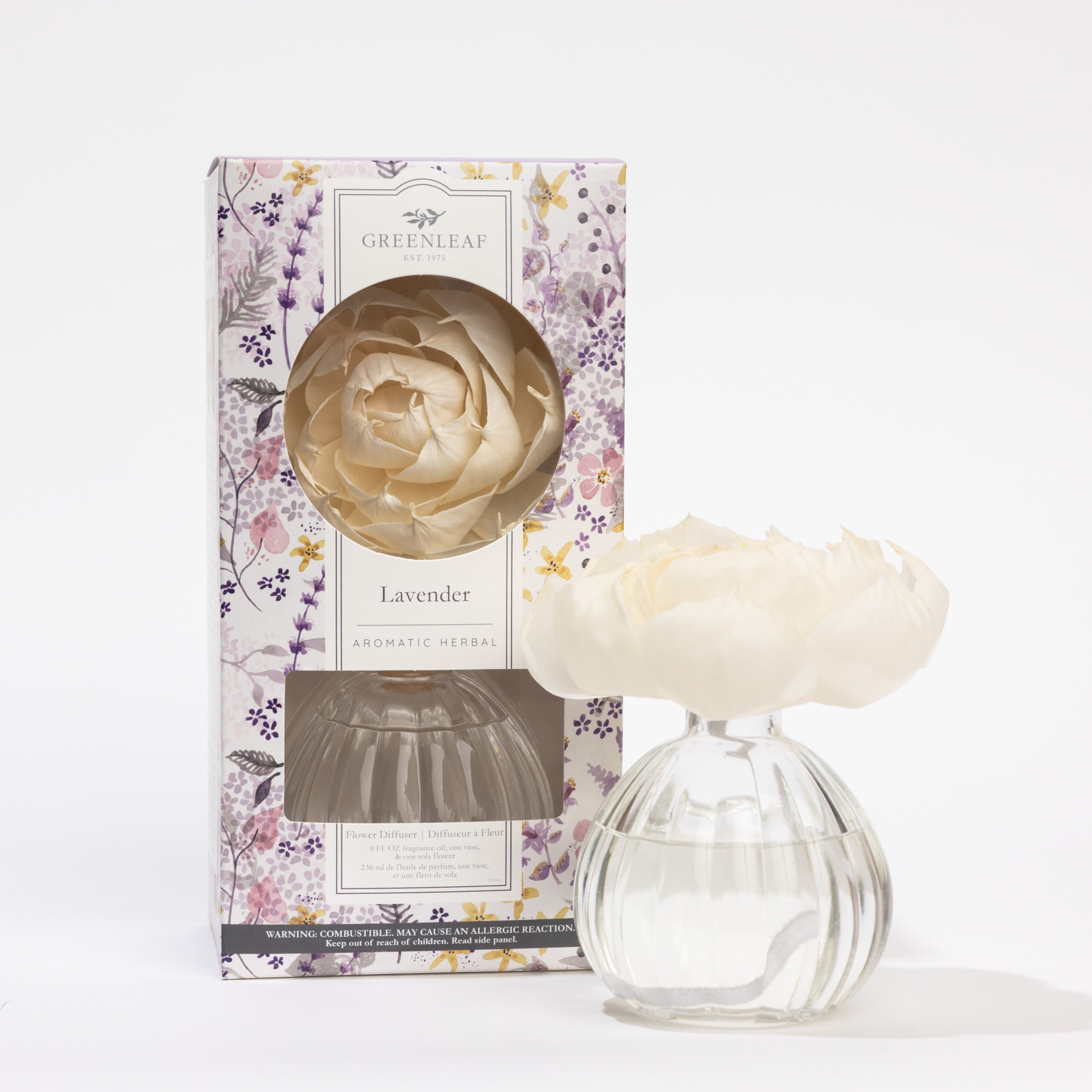 The Greenleaf Gifts Lavender Flower Diffuser (GLG966514S) features an 8 oz glass vase with clear liquid, a white flower diffuser, and comes in a floral box. Enjoy its fresh lavender scent for up to 60 days.