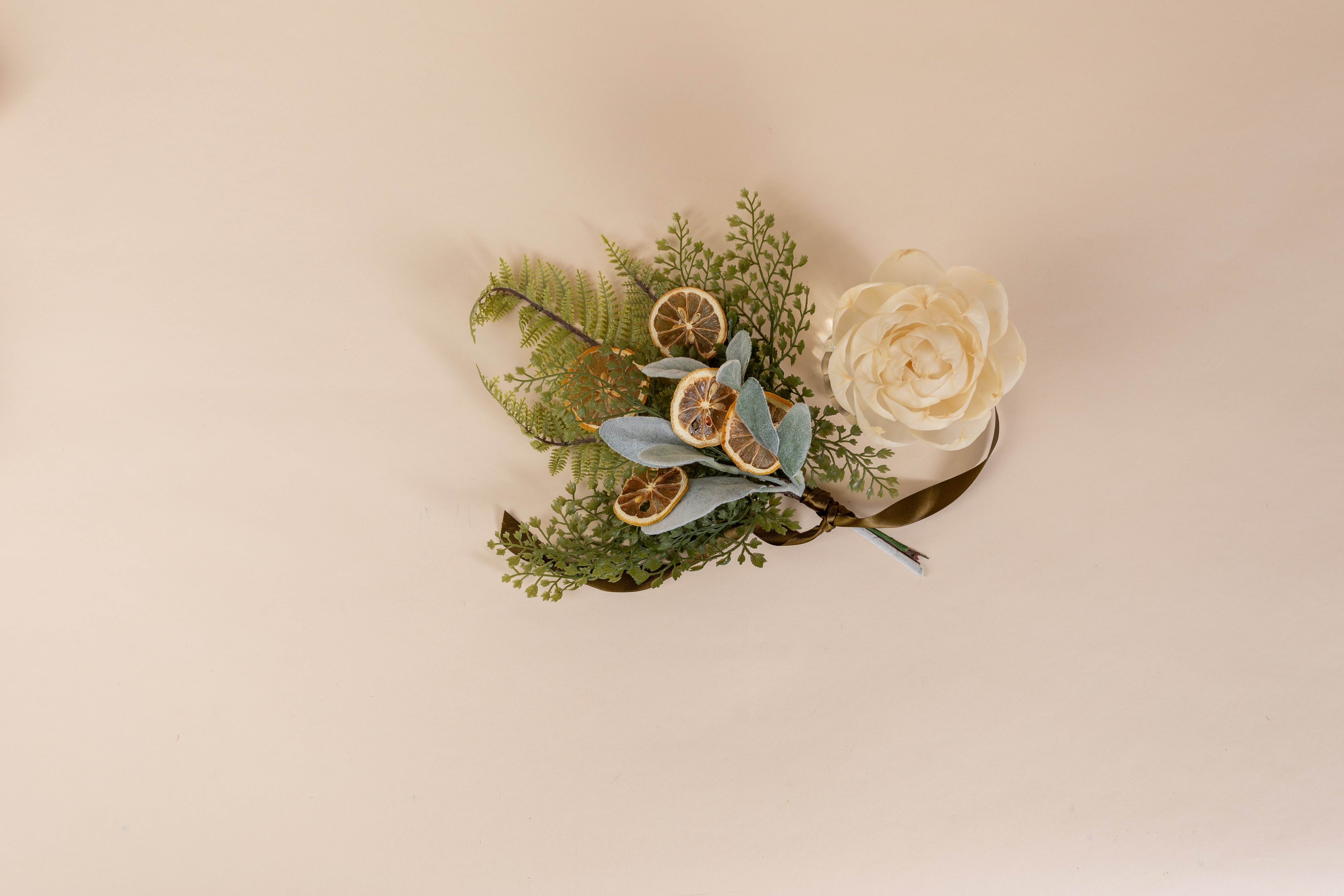 The Willow & Sage Flower Diffuser by Greenleaf Gifts features green ferns, dried lemon slices, gray-blue leaves, and a cream faux flower. This 8 oz decor stays fresh for up to 60 days and sits on a beige background.