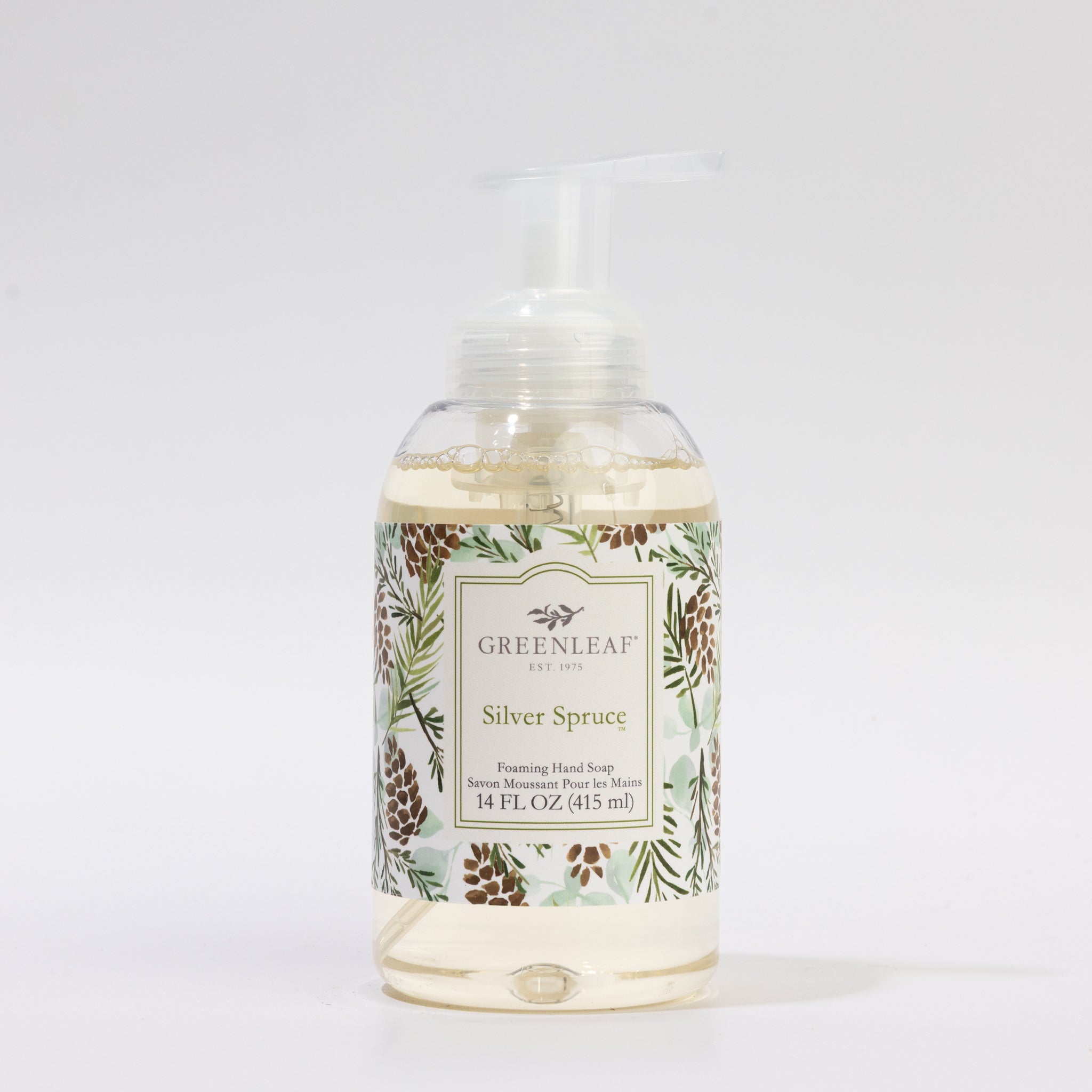 Greenleaf Gifts Silver Spruce Foaming Hand Soap comes in a clear plastic pump bottle with pinecone and spruce artwork, containing 14 fl oz (415 ml)—an ideal match for a 14 ounce tumbler or glass container in your bathroom.
